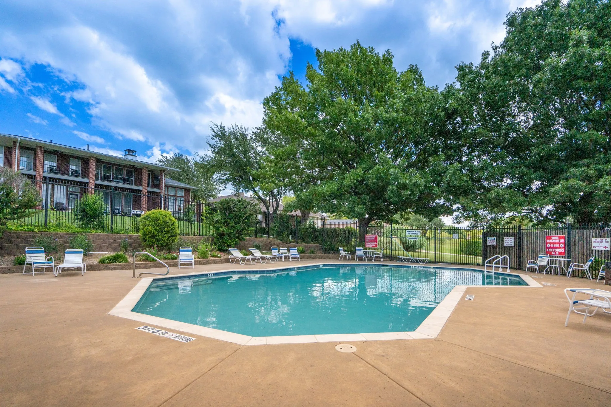 Resort-style pool with integrated steps and a surrounding concrete patio