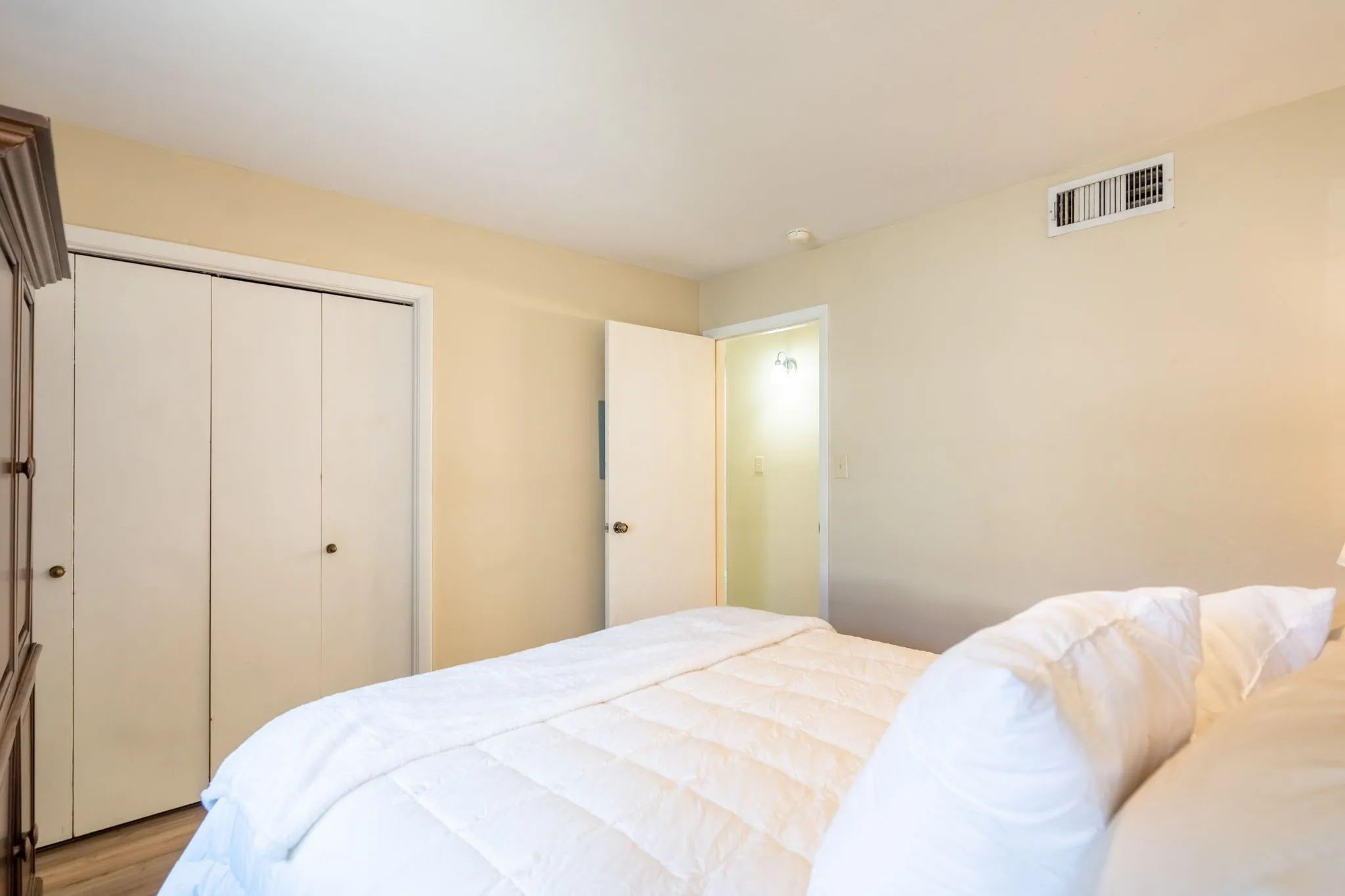 Wood-finish flooring with white trim, double bi-fold closet doors, and recessed lighting