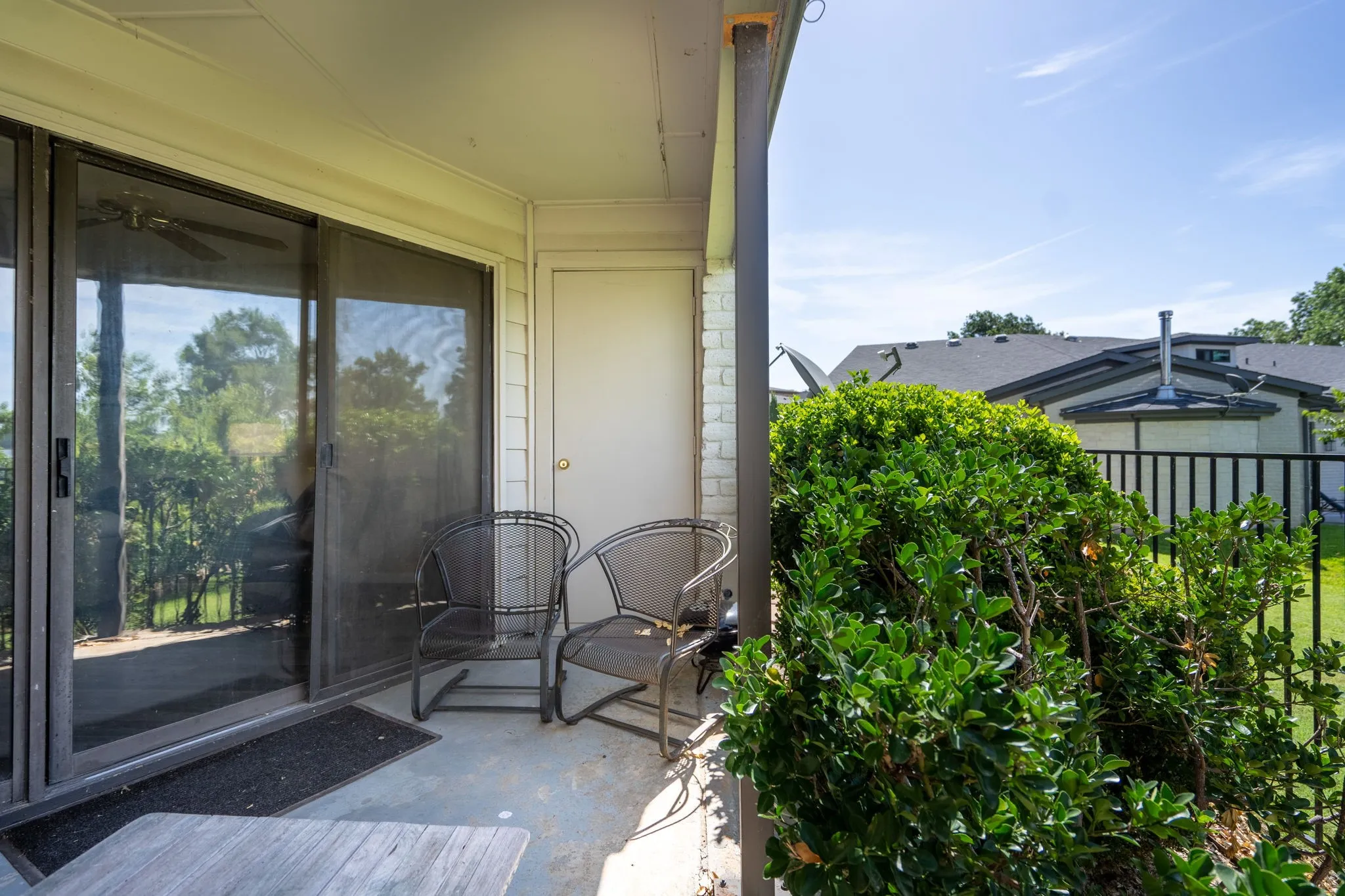 Outdoor patio with concrete flooring, sliding glass door, and exterior storage