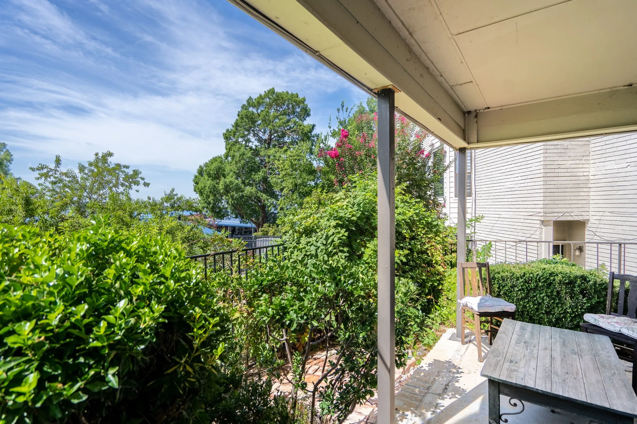 Covered outdoor patio with a concrete surface and a metal railing