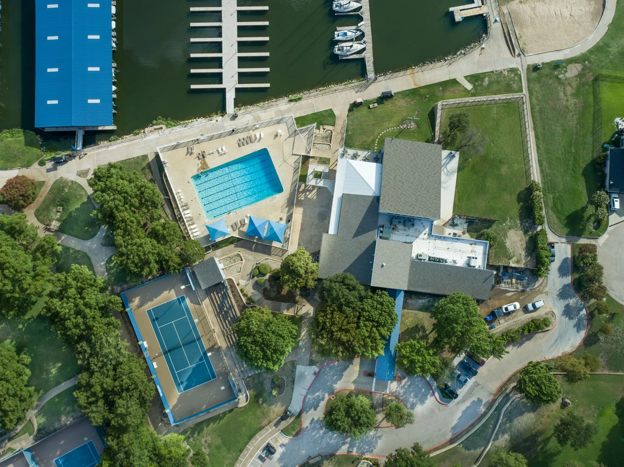 Marina access with multiple boat slips, outdoor swimming pool, tennis courts, and clubhouse facilities