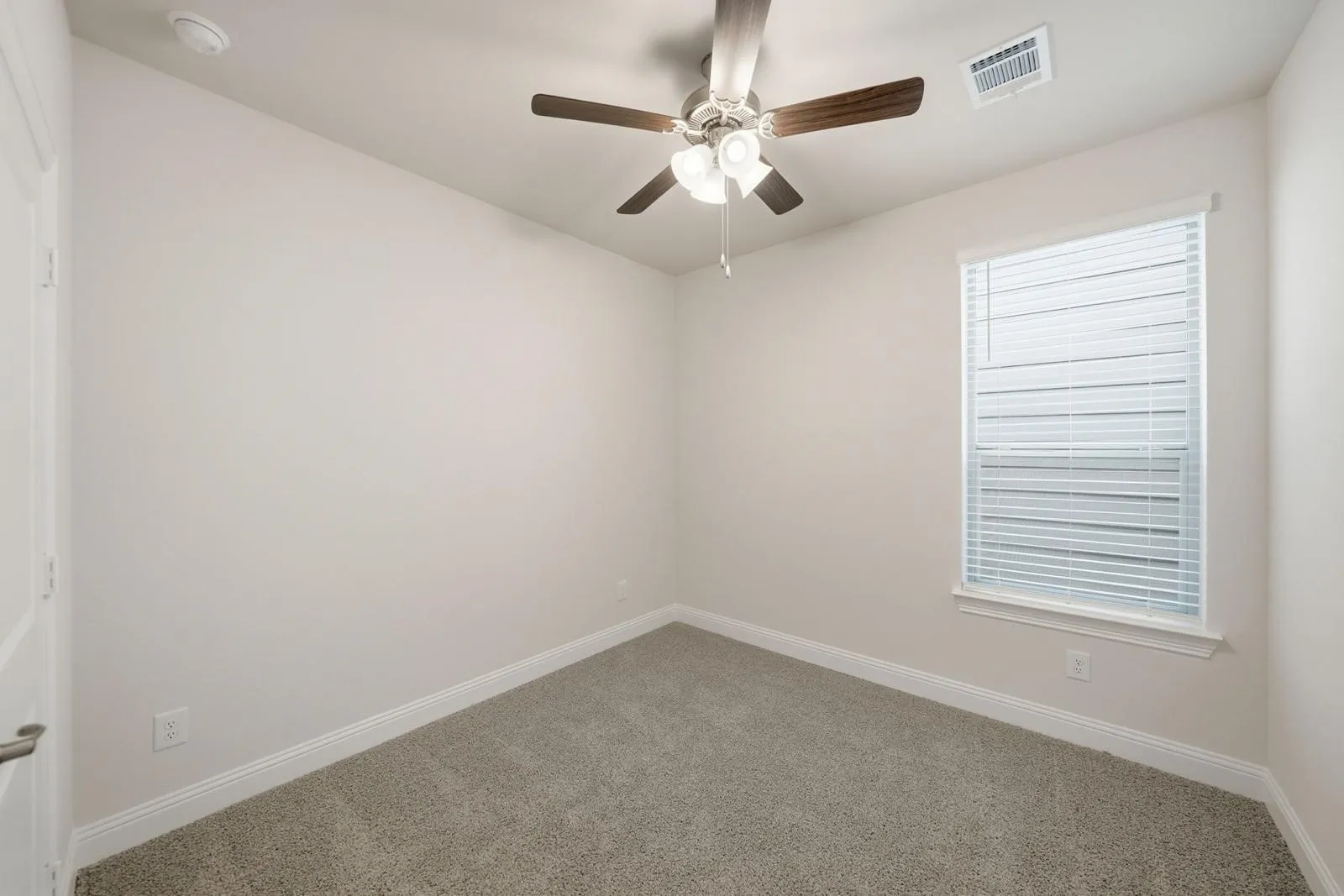 Wall-to-wall carpeting, ceiling fan with integrated lighting, and window with blinds