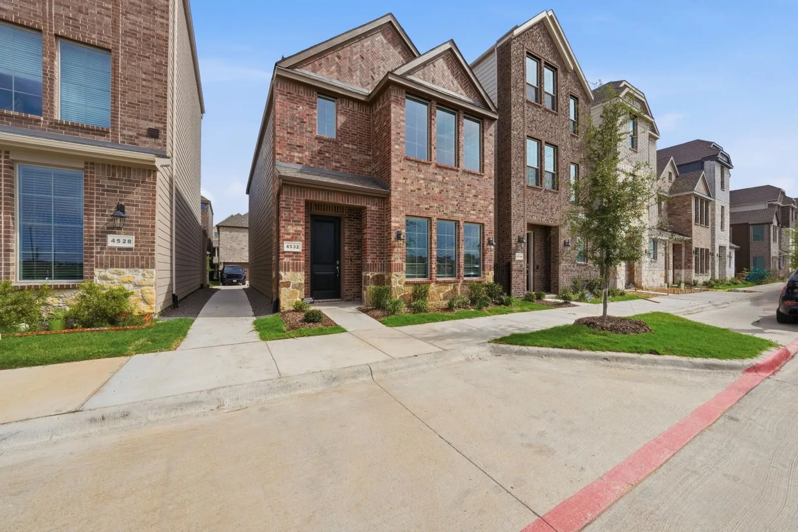 Brick exterior with stone accents, mature landscaping, and a paved driveway