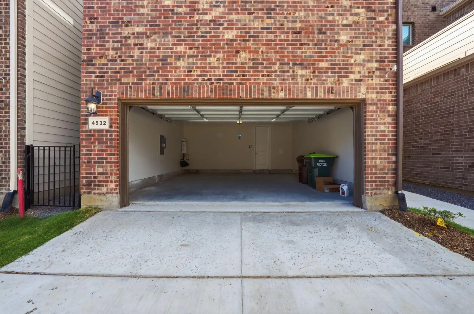 Brick exterior with an attached garage, featuring a metal garage door and a concrete driveway