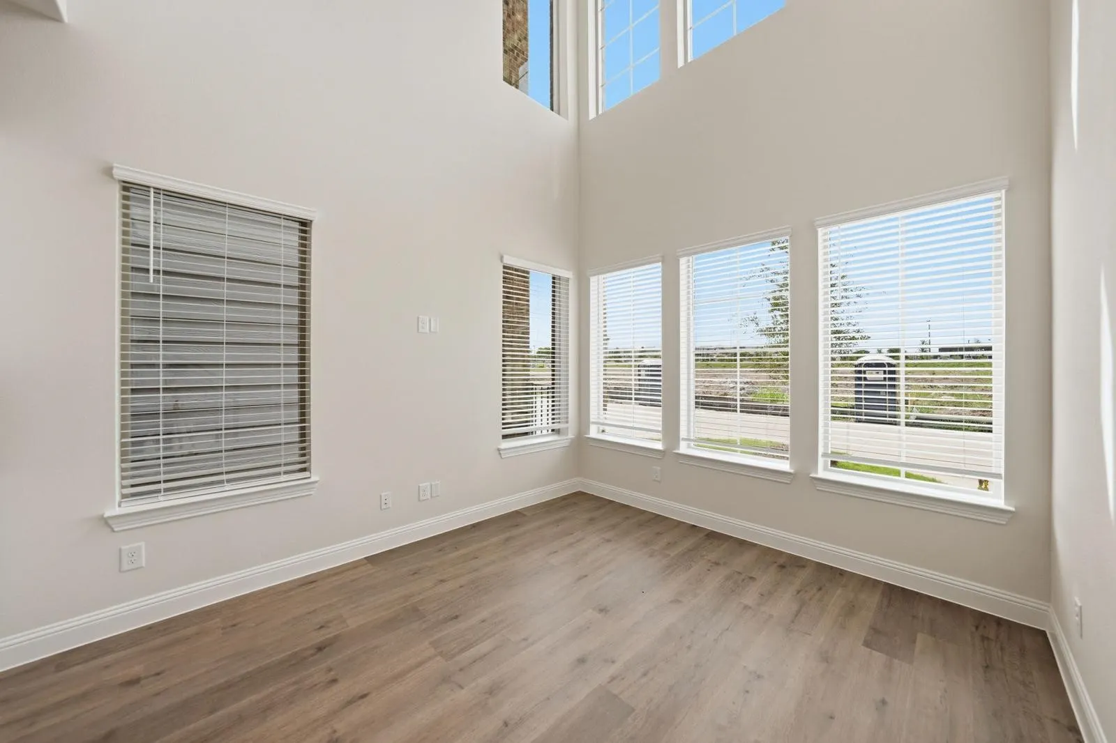 Two-story ceilings, a wall of windows, and wood-finish flooring