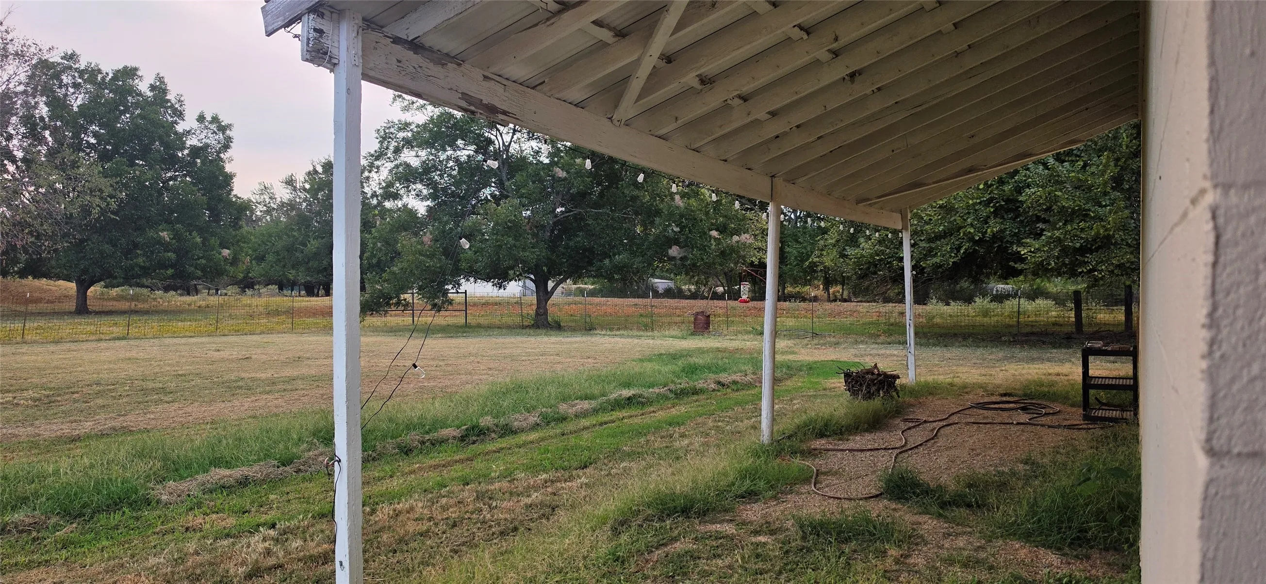 Covered patio featuring exposed rafters and supporting posts