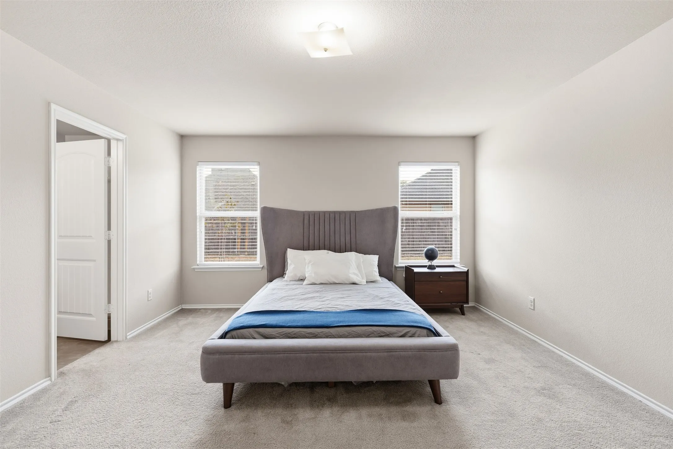 Located on the first floor, the spacious primary bedroom is thoughtfully separated from the secondary bedrooms upstairs.