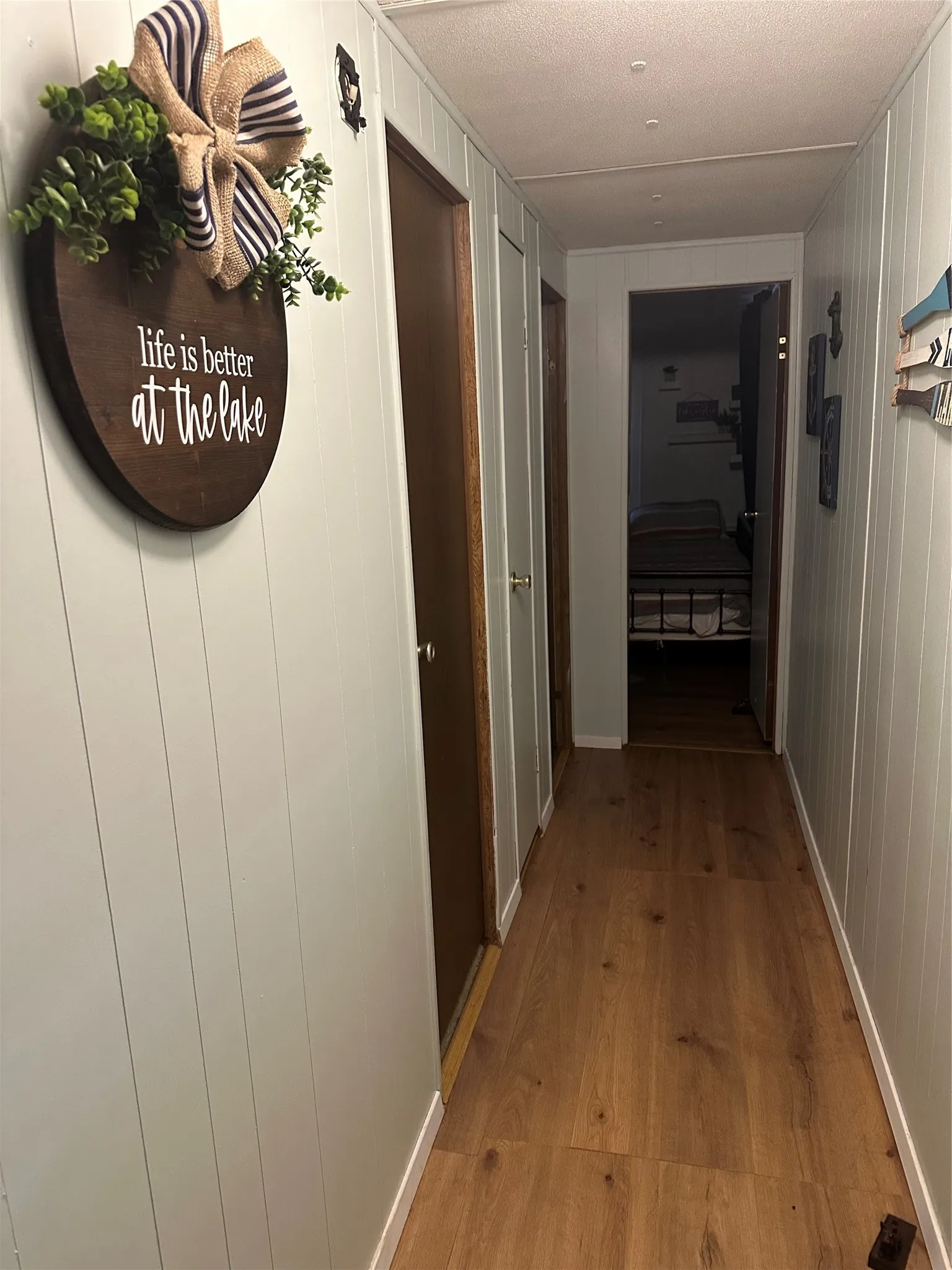 Hallway with wood-finish flooring and paneling