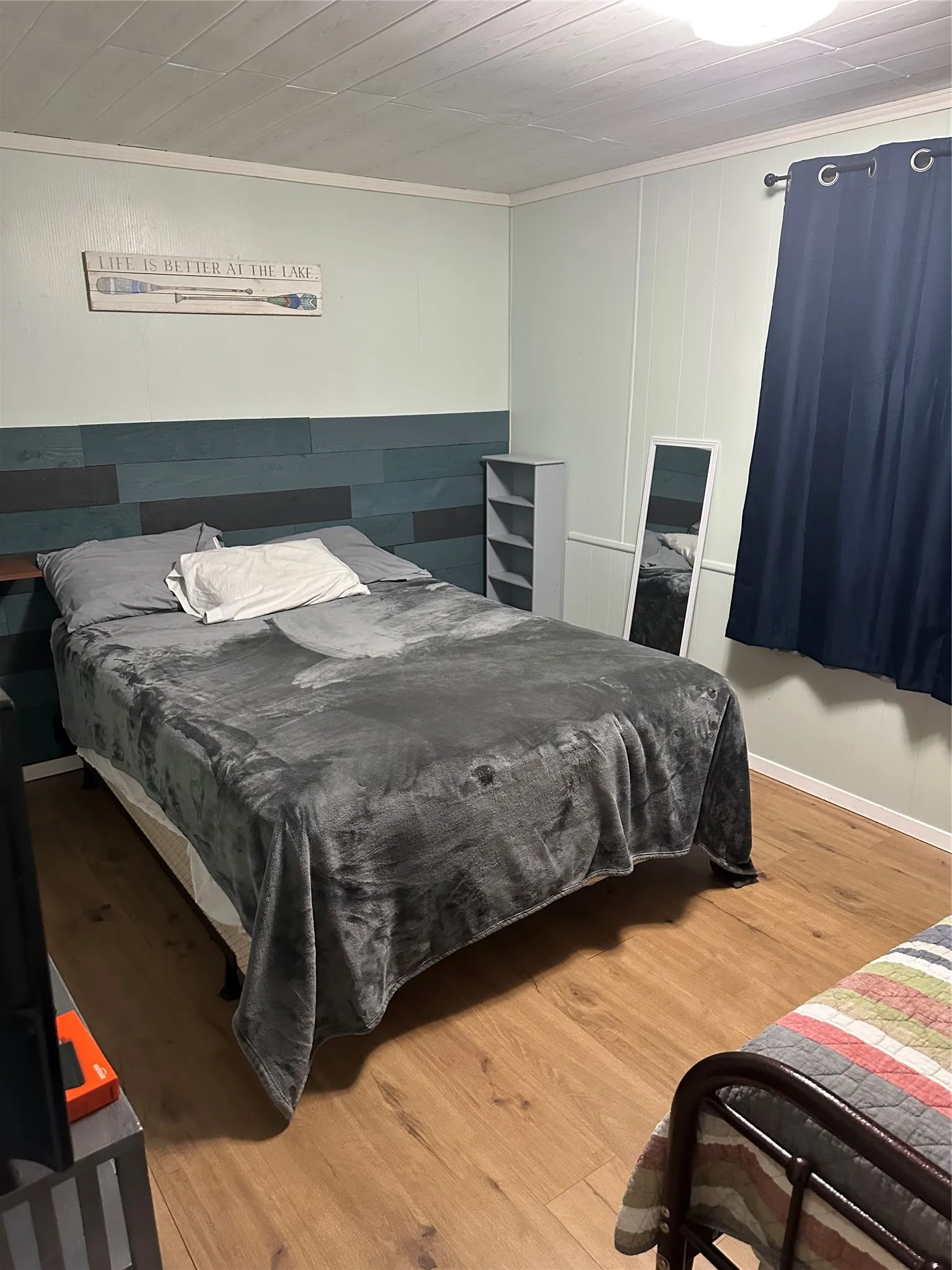 Wood-finish flooring throughout, complemented by a light green wall finish