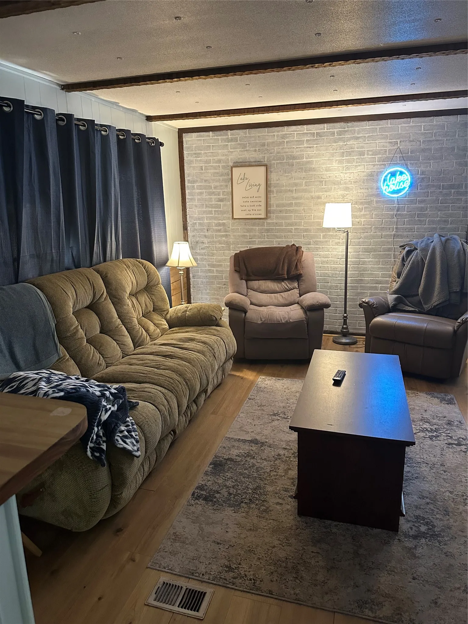 Wood-finish flooring with a white brick-style accent wall