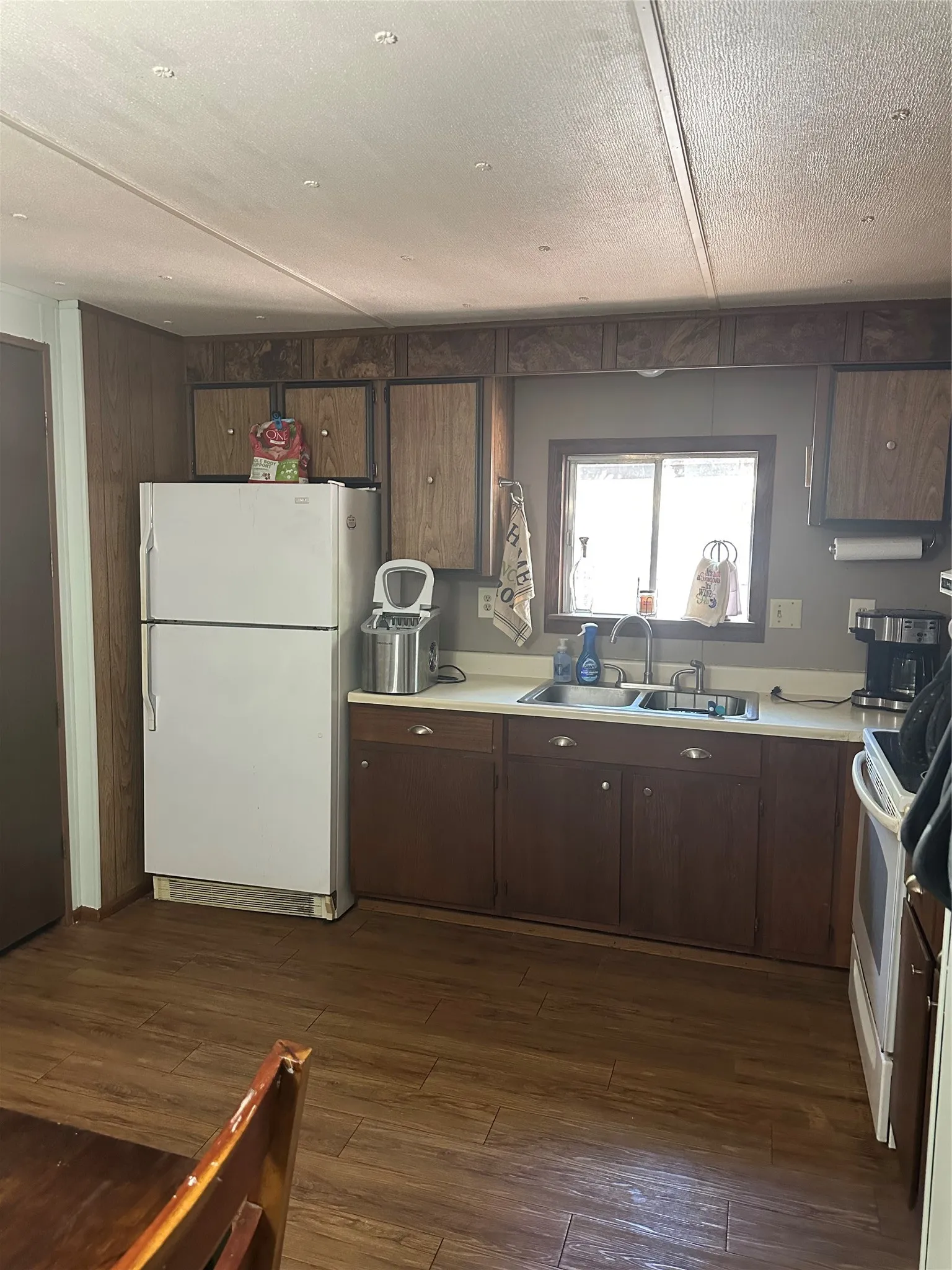 Kitchen featuring wood-finish flooring, a double basin stainless steel sink, and a window above the sink
