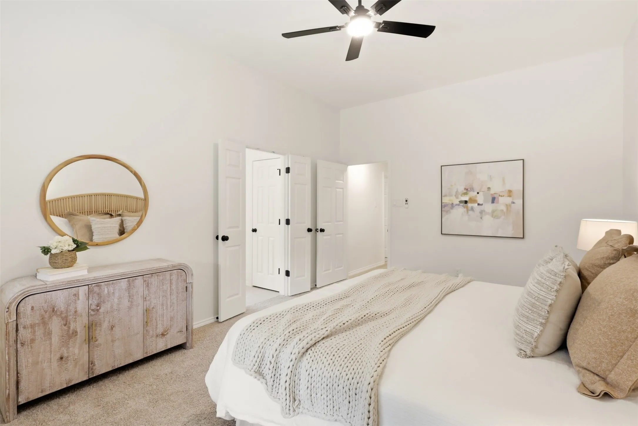 White walls, carpet flooring, a ceiling fan with light, and bi-fold doors