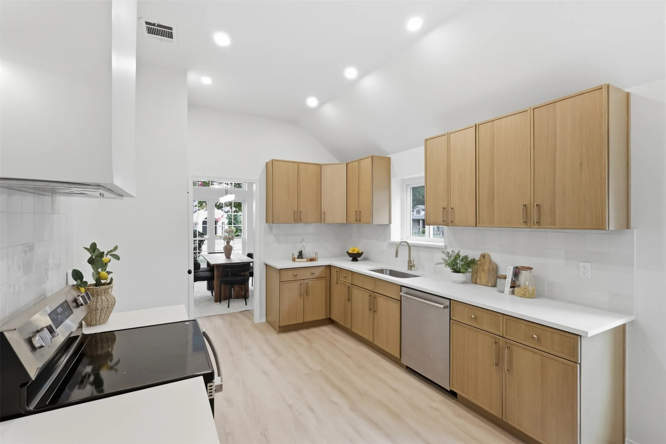 Kitchen featuring wood-finish cabinetry, stainless steel appliances, white countertops, and a subway tile backsplash