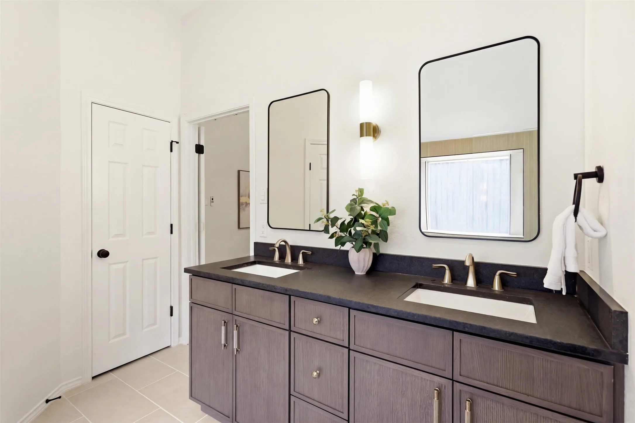 Double vanity with dark wood-finish cabinetry and dual undermount sinks