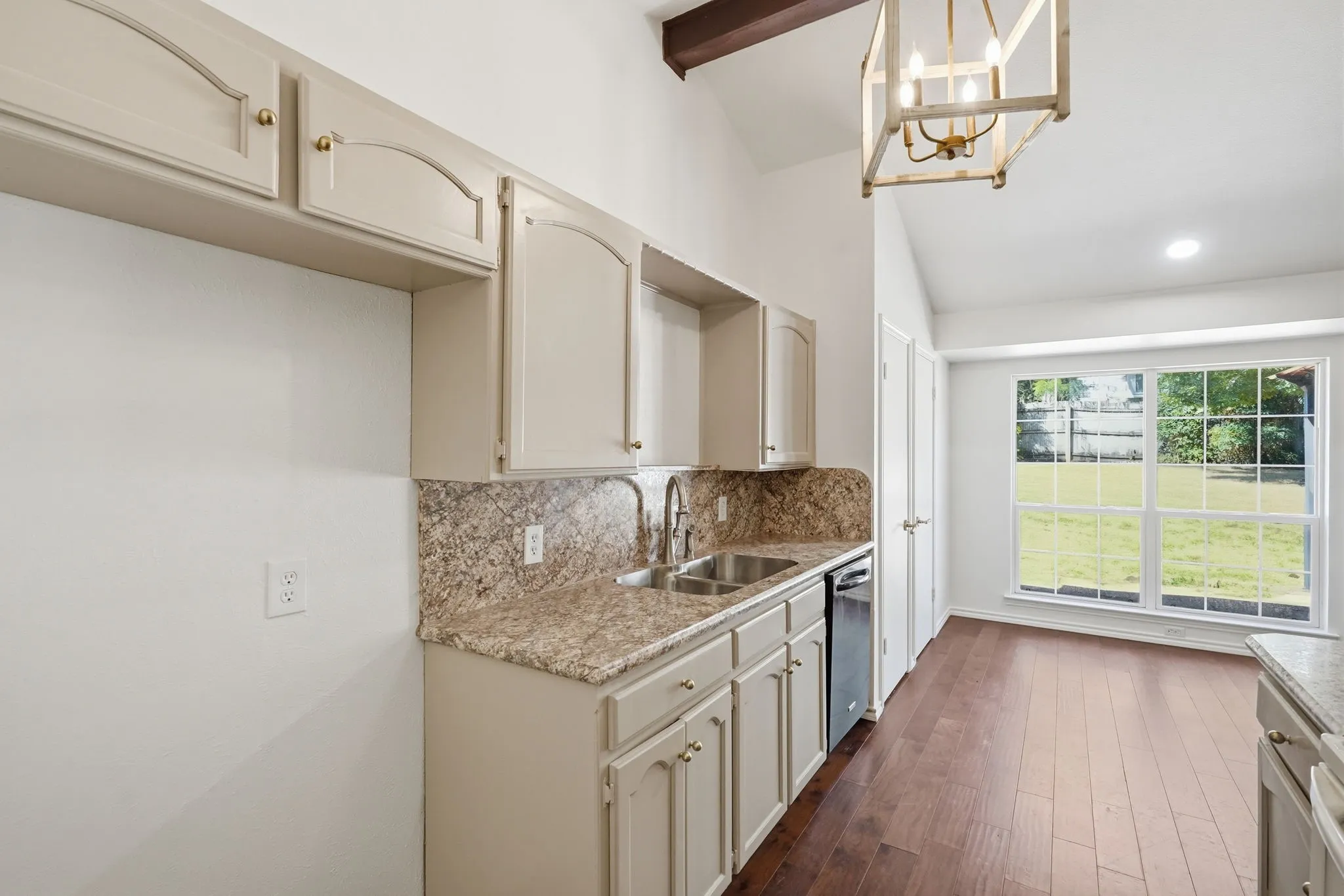 Kitchen with granite countertops, dual basin stainless steel sink, and wood-finish flooring