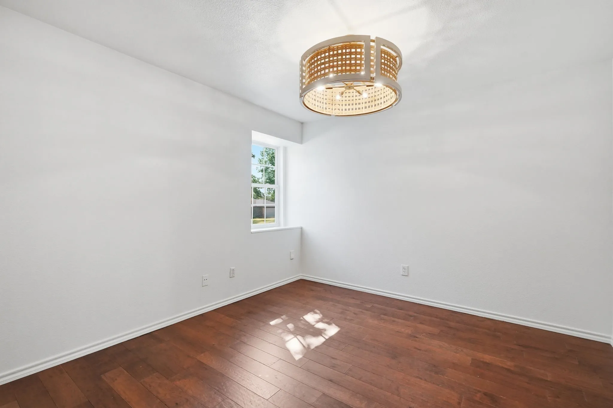 Wood-finish flooring, white walls, and a contemporary ceiling fixture