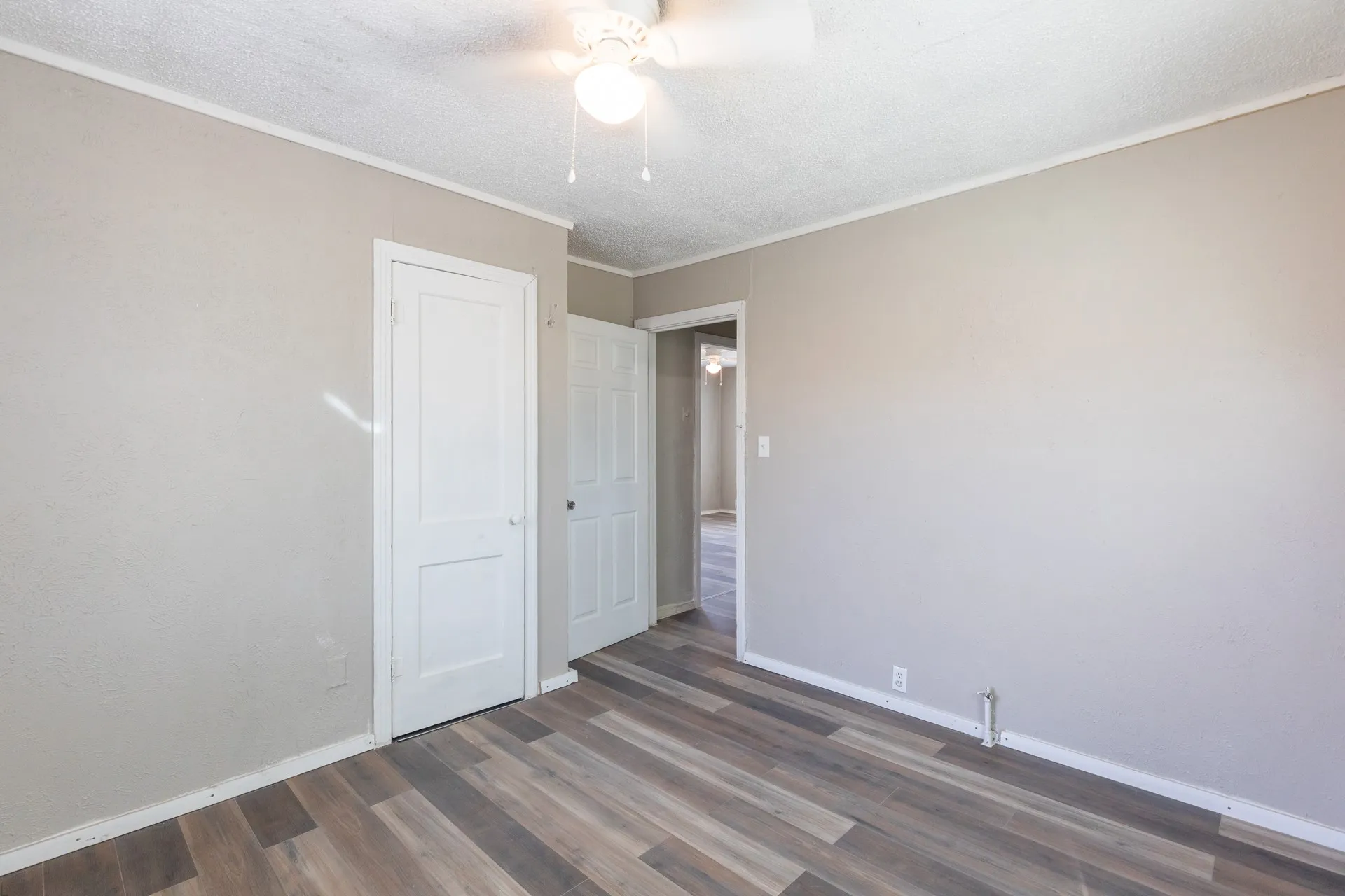Wood-finish flooring, ceiling fan, and painted walls