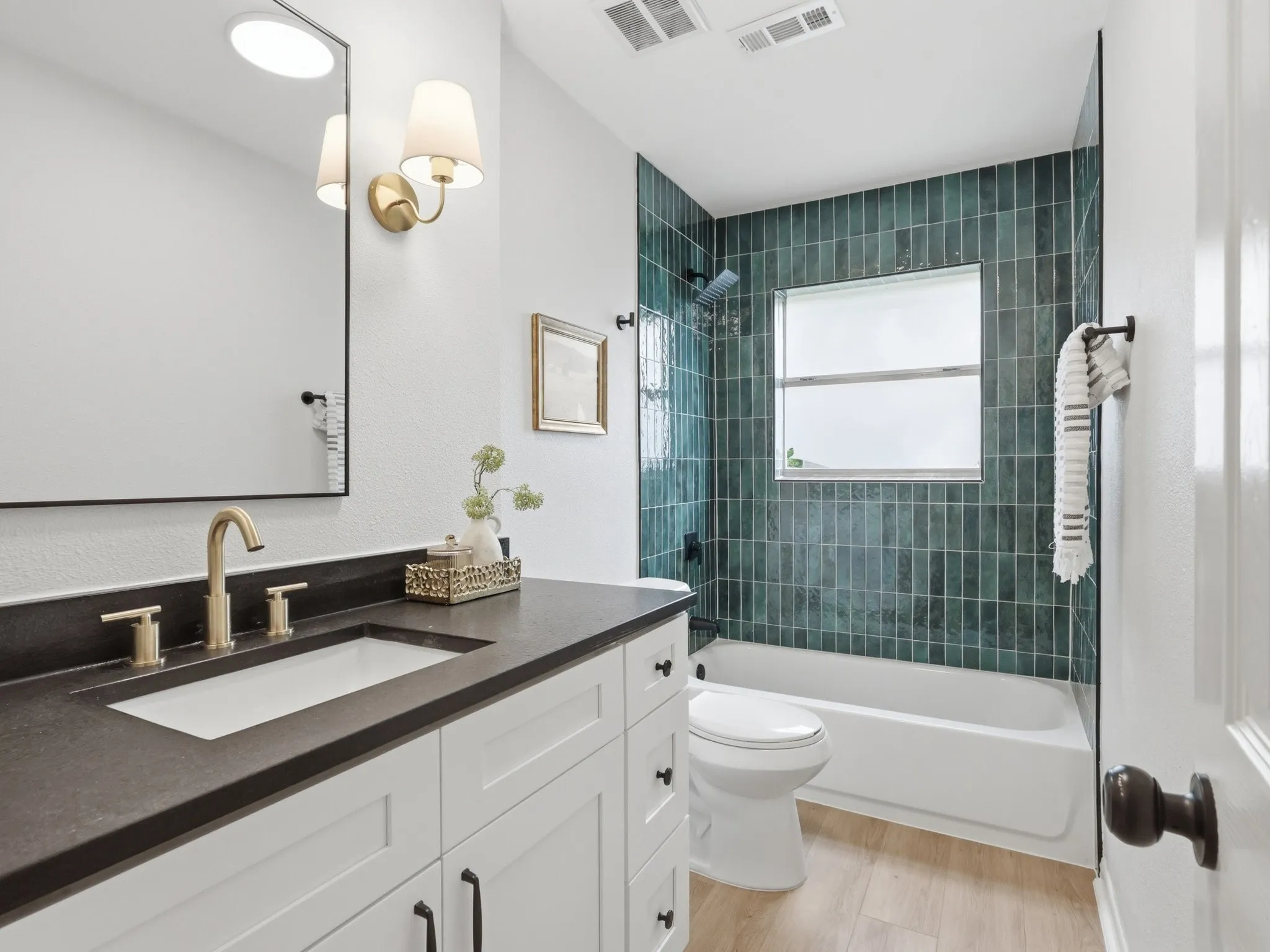 Bathroom featuring a vanity with a dark countertop and integrated rectangular sink