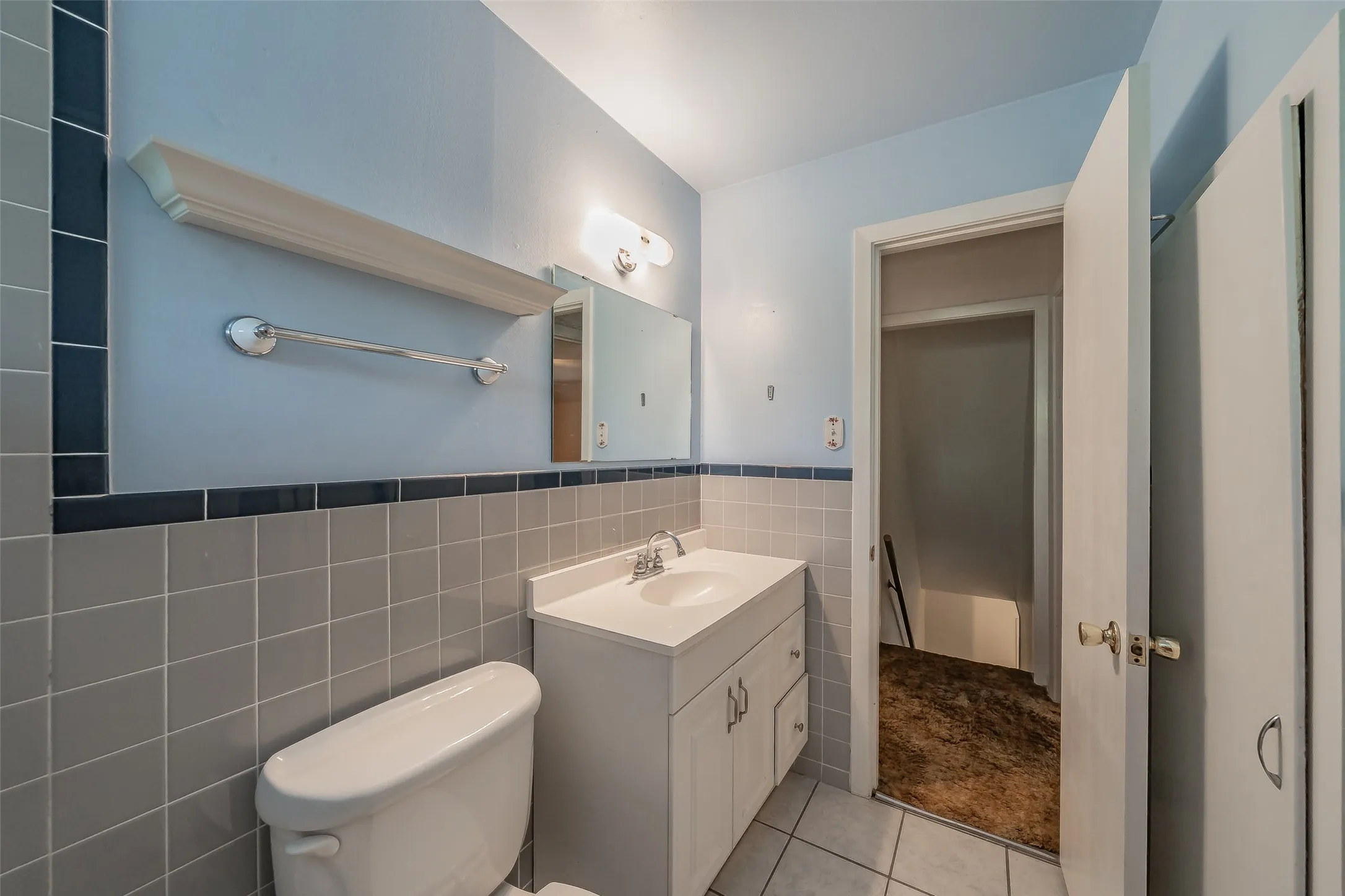 White vanity with an integrated sink, polished chrome faucet, and overhead lighting