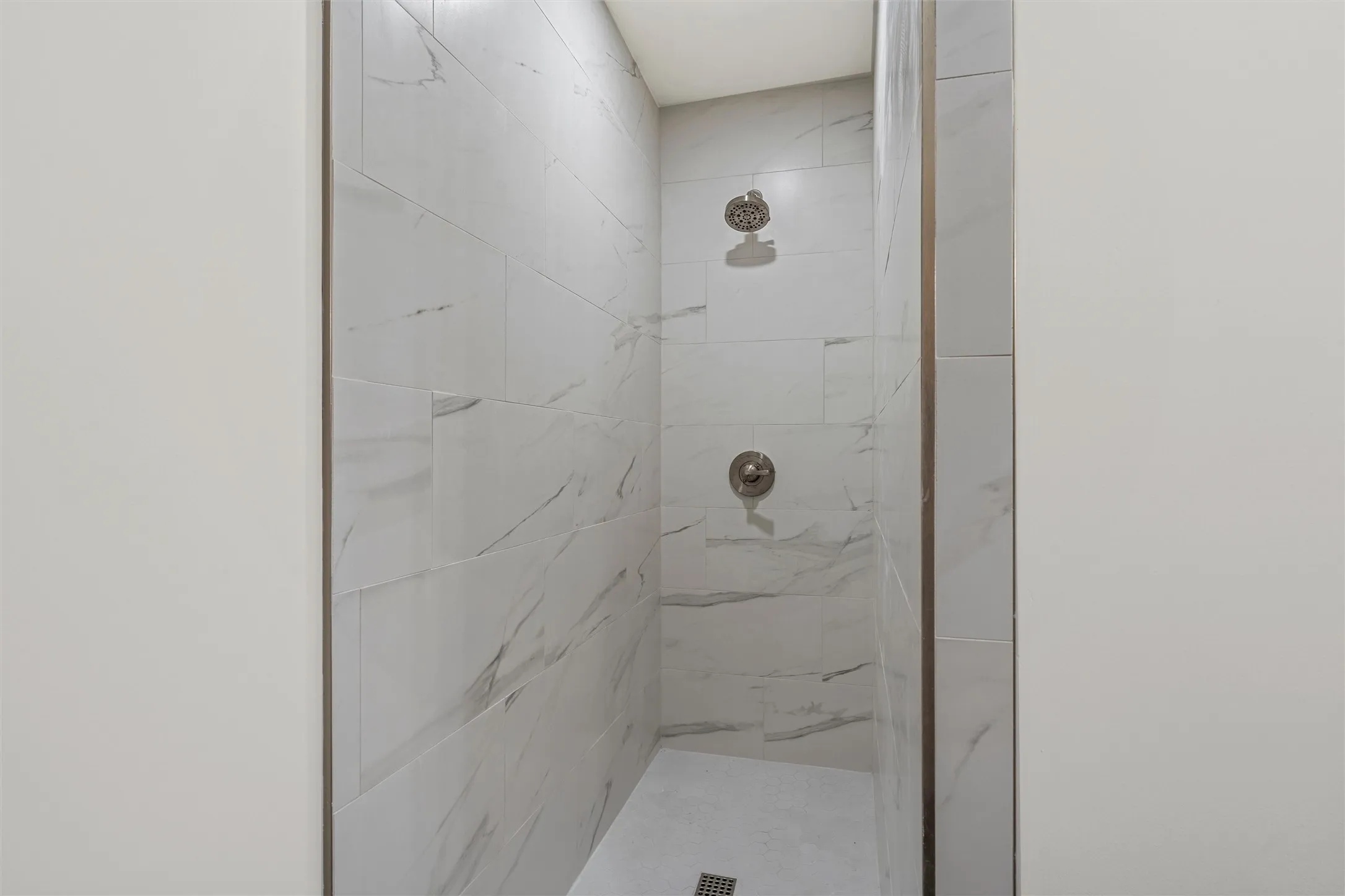 Walk-in shower with large-format tile surrounds and dual shower heads