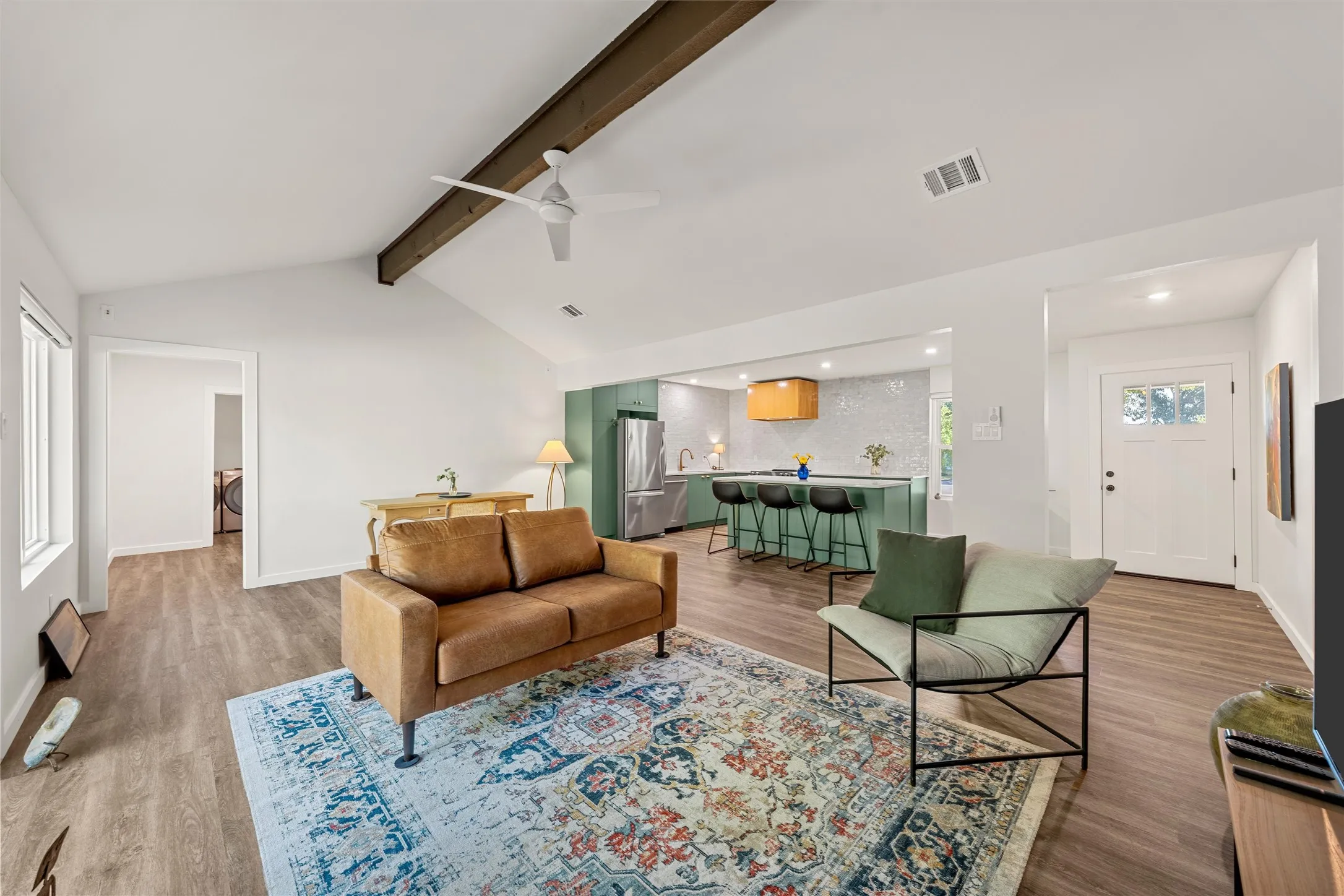 Vaulted ceiling with exposed wood beam, wood-finish flooring, recessed lighting, and a modern ceiling fan
