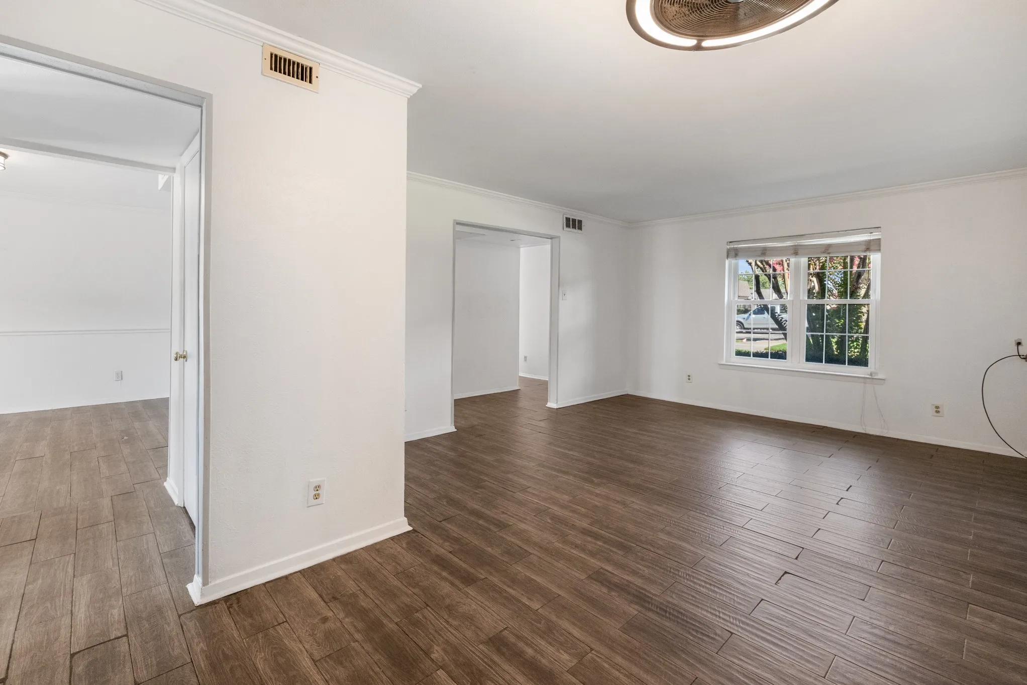 Wood-finish flooring throughout, white crown molding, and recessed lighting