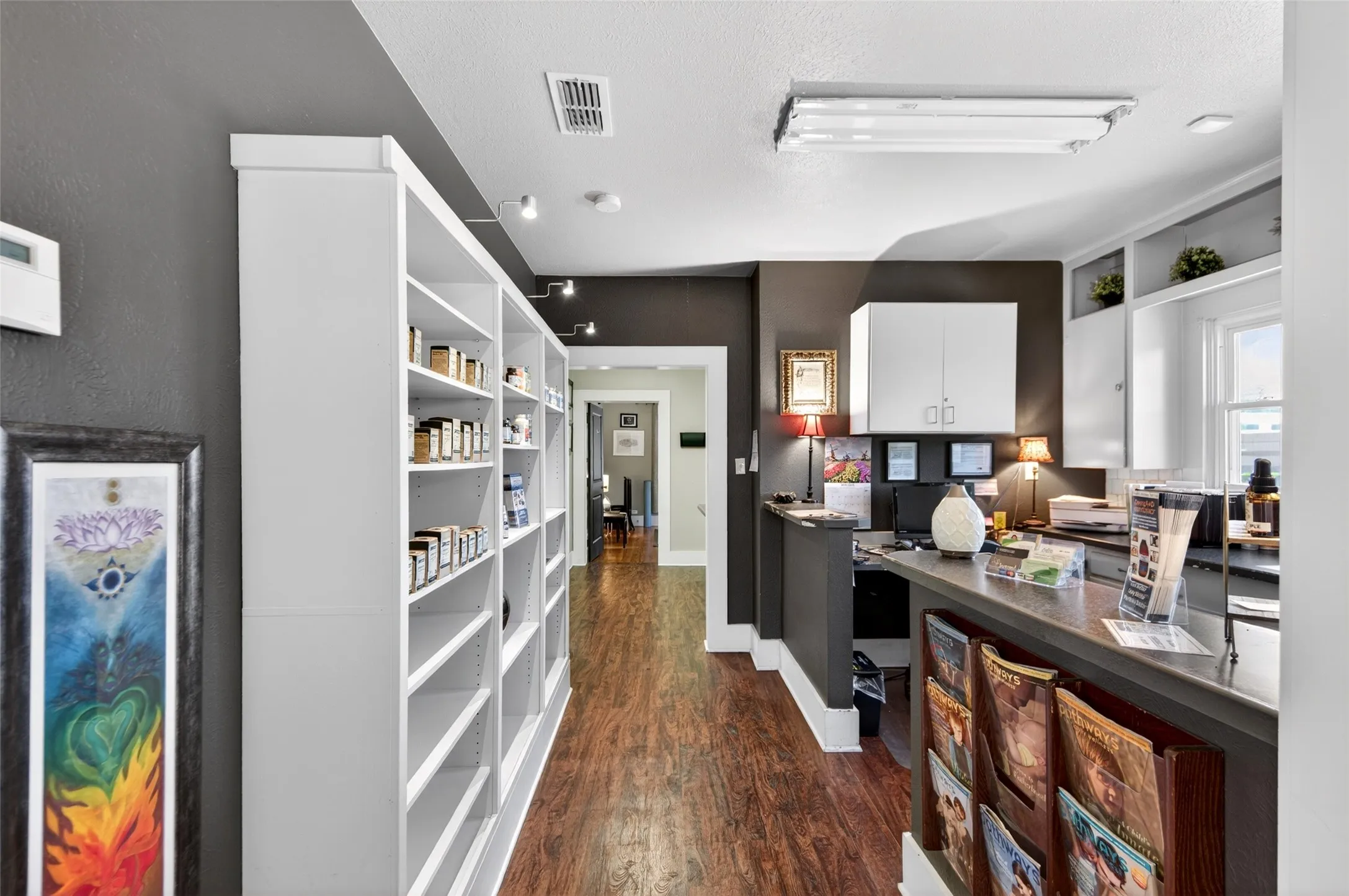 Wood-finish flooring, recessed lighting, and track lighting illuminate the space