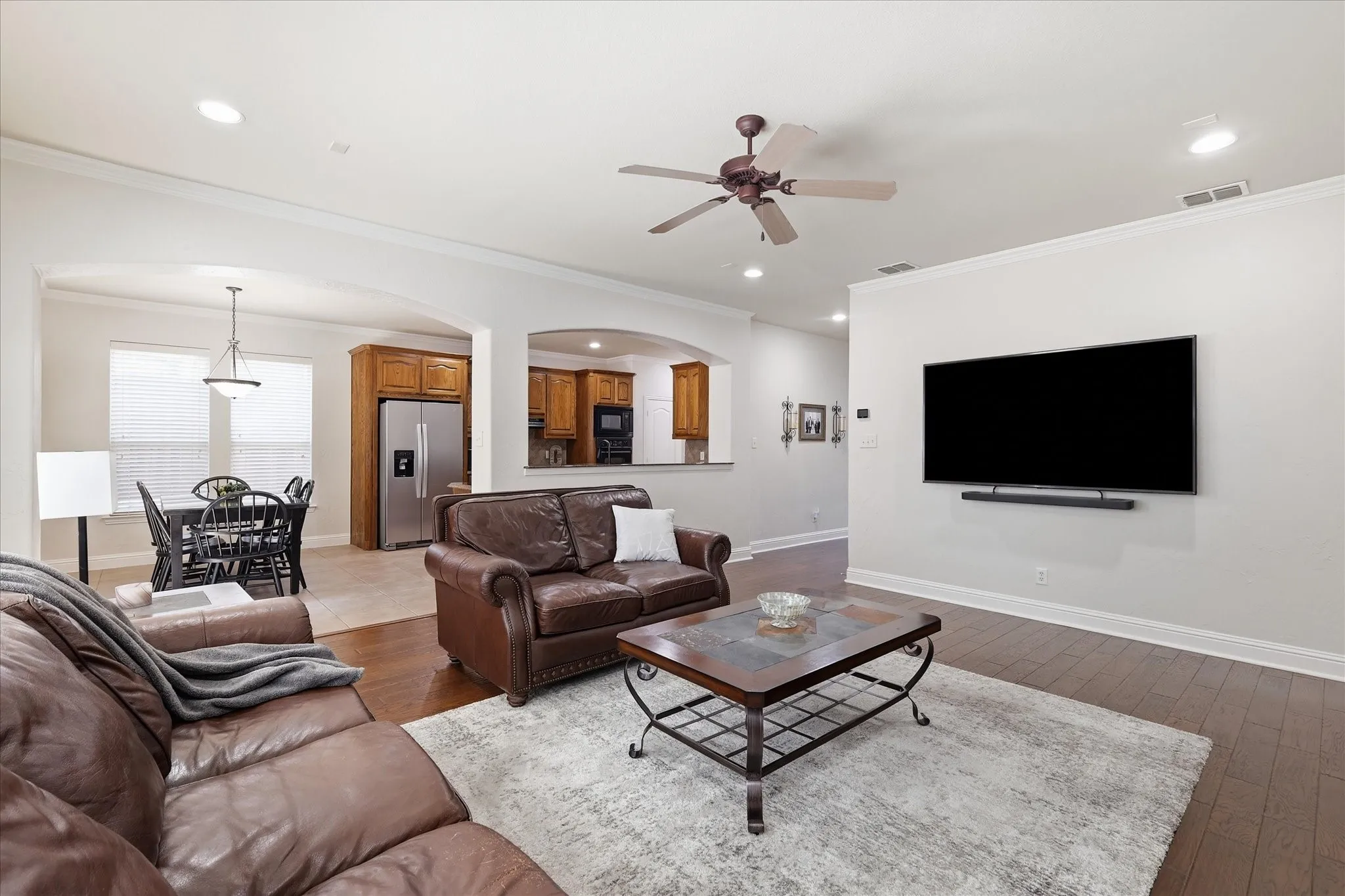 Open-concept living space featuring wood-finish flooring, recessed lighting, and a ceiling fan