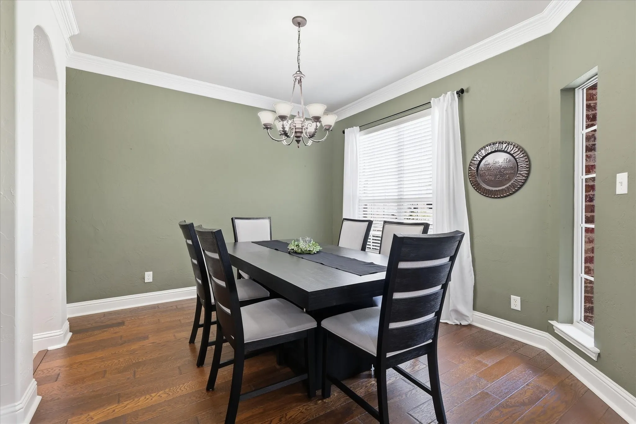 Archway entry, wood-finish flooring, crown molding, double window with blinds, and a built-in light fixture