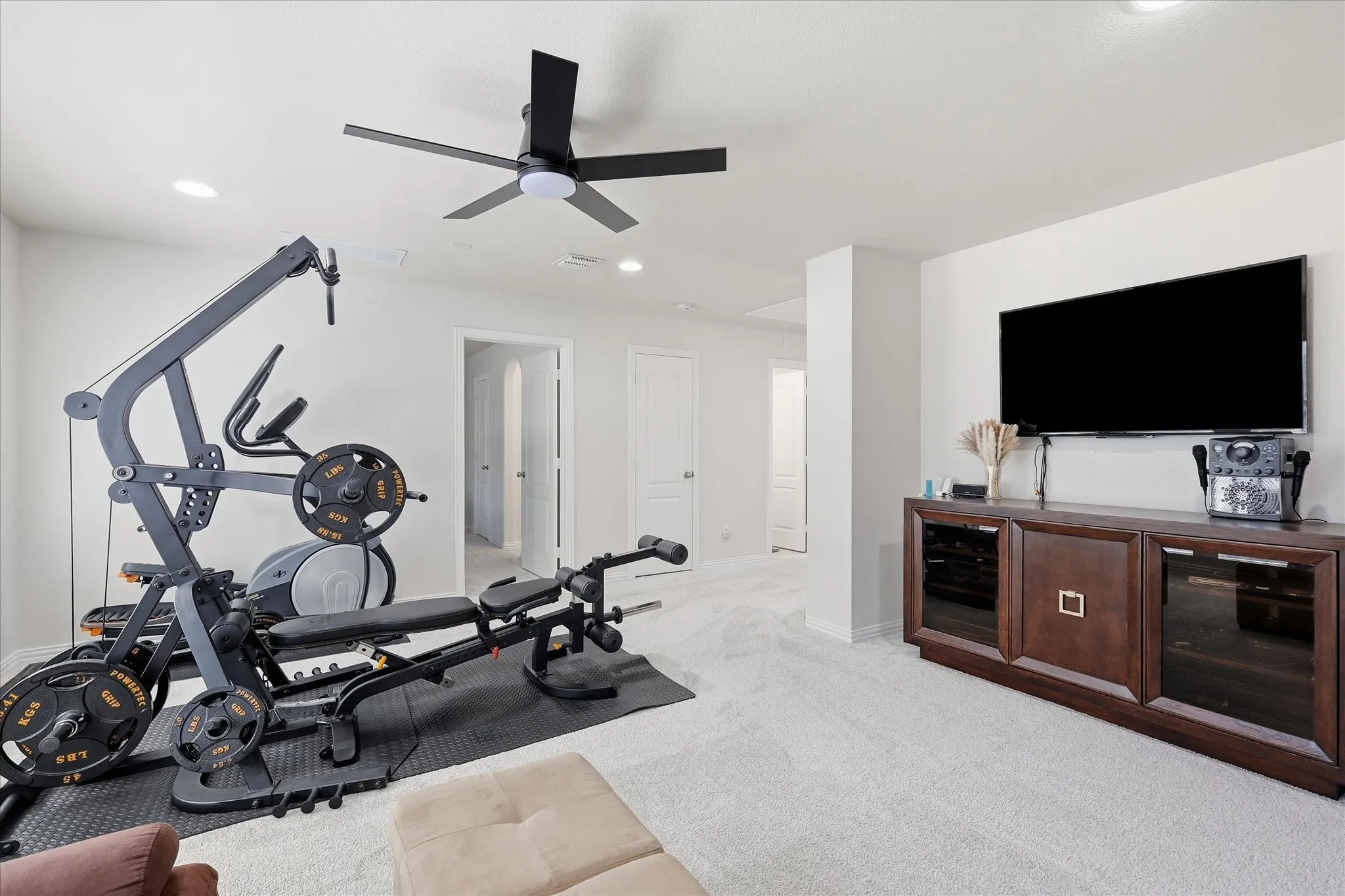 Recessed lighting, ceiling fan, and light-toned carpeting