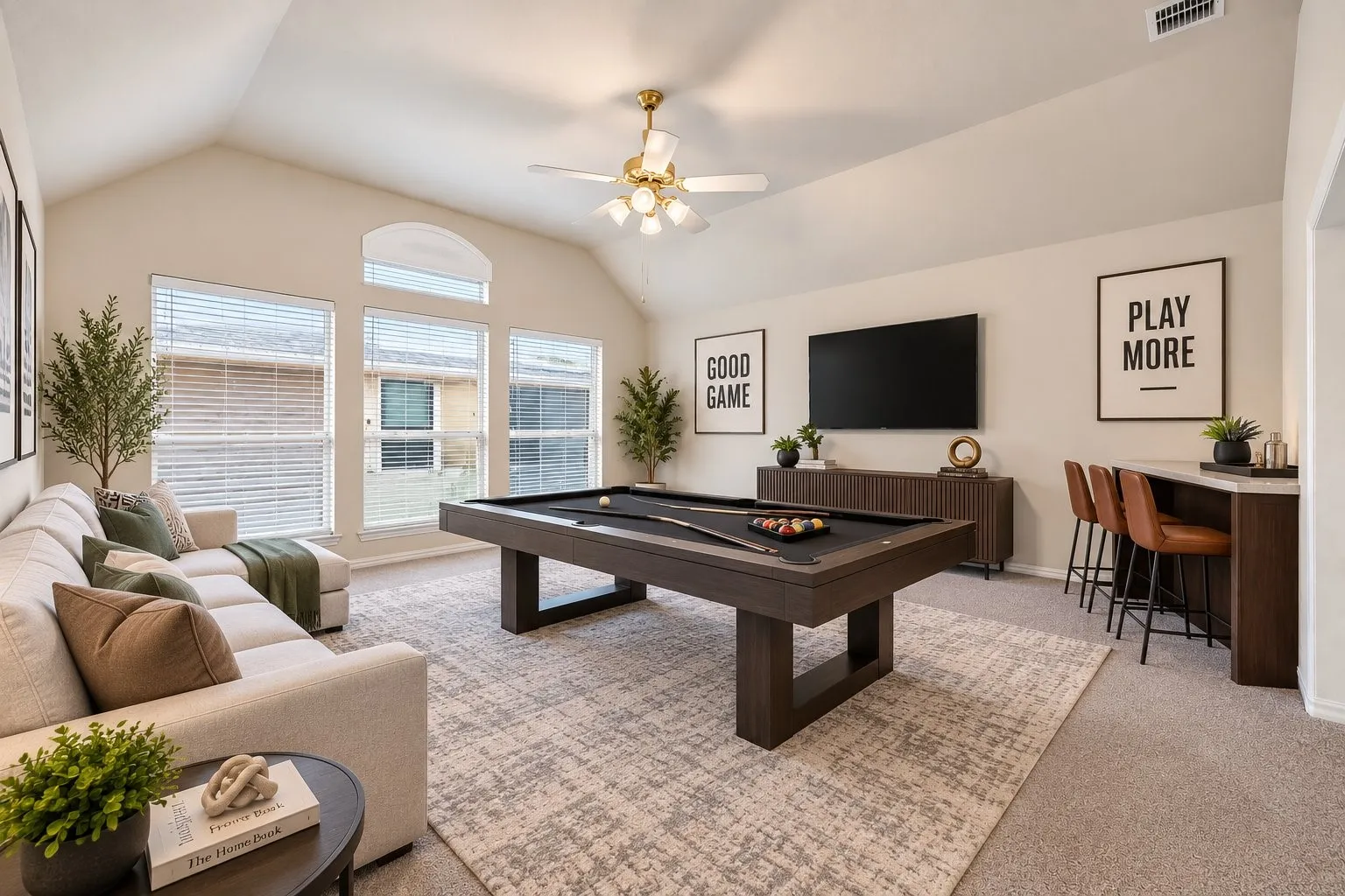 Vaulted ceiling with a ceiling fan, multiple windows with blinds, built-in wet bar with a countertop, and carpeting