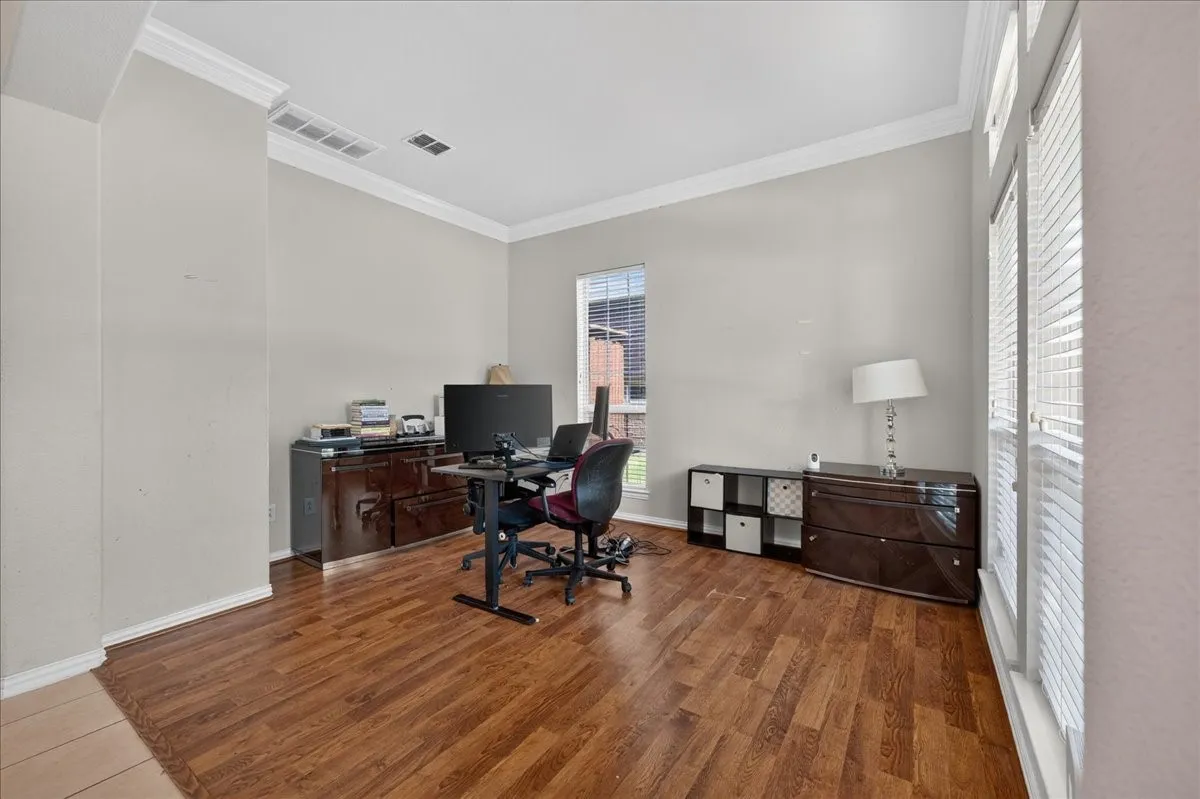 Wood-finish flooring with crisp white crown molding and trim
