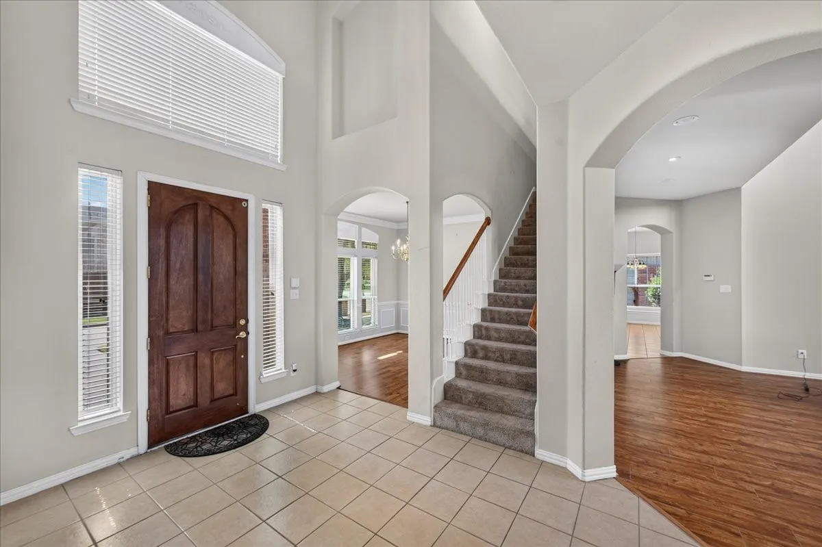 Two-story entryway with a wood-finish door, side light windows, and transom window