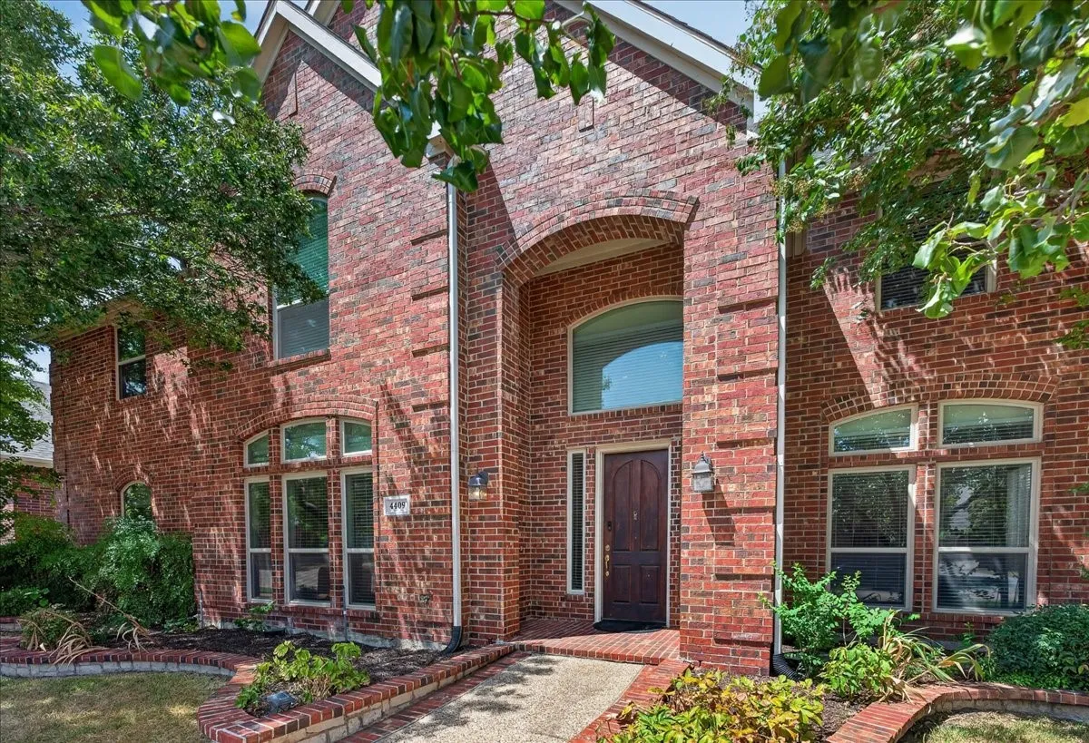 Brick exterior with arched entryway, transom window, and multiple window styles