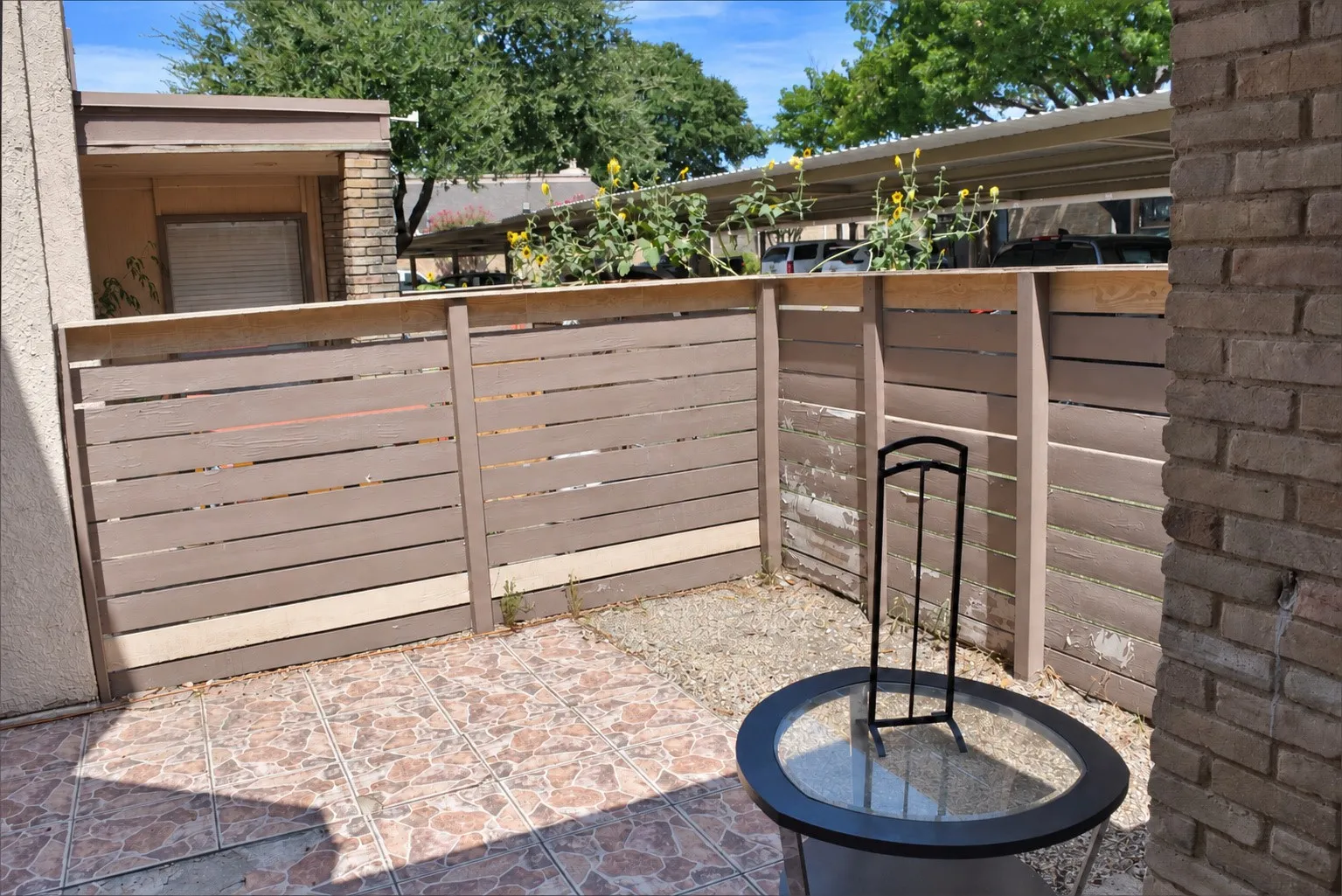 Paved patio area featuring tile flooring and a privacy fence