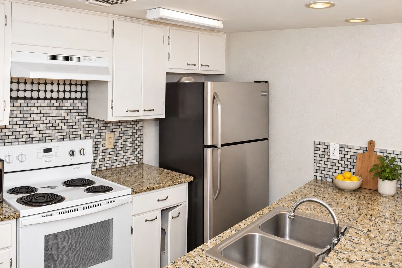 Kitchen featuring white cabinetry, granite-style countertops, stainless steel refrigerator, white electric range, and a mosaic tile backsplash