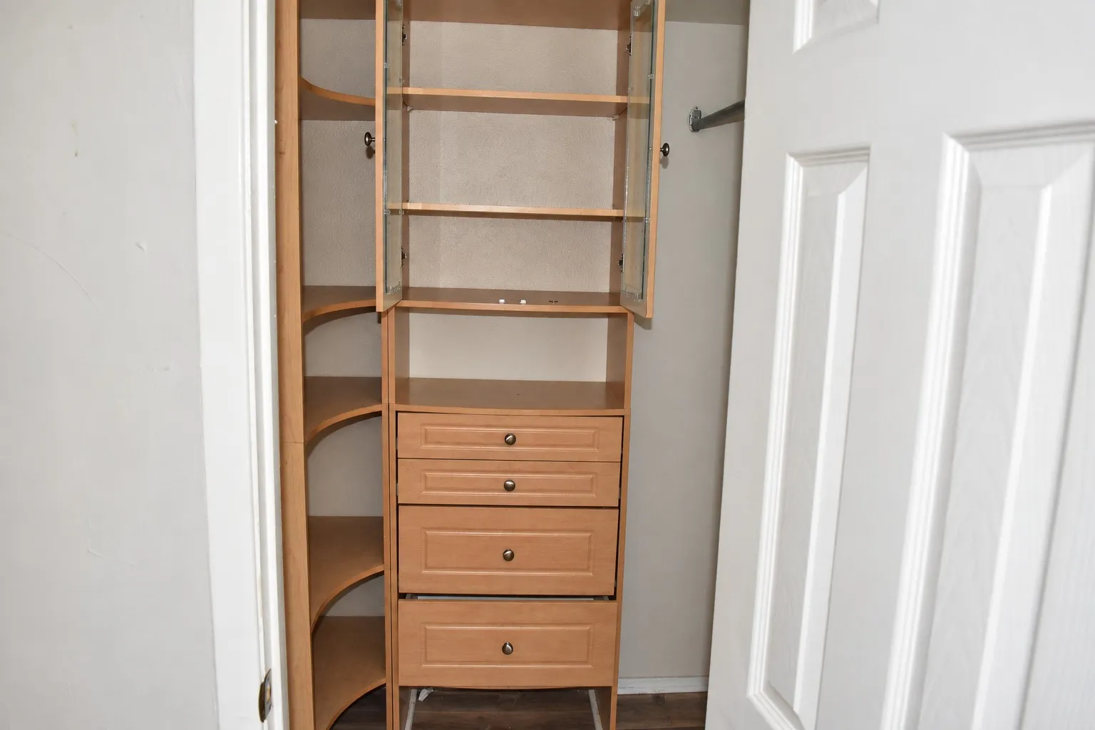 Custom closet system featuring built-in shelving, drawers, and glass-front upper cabinetry