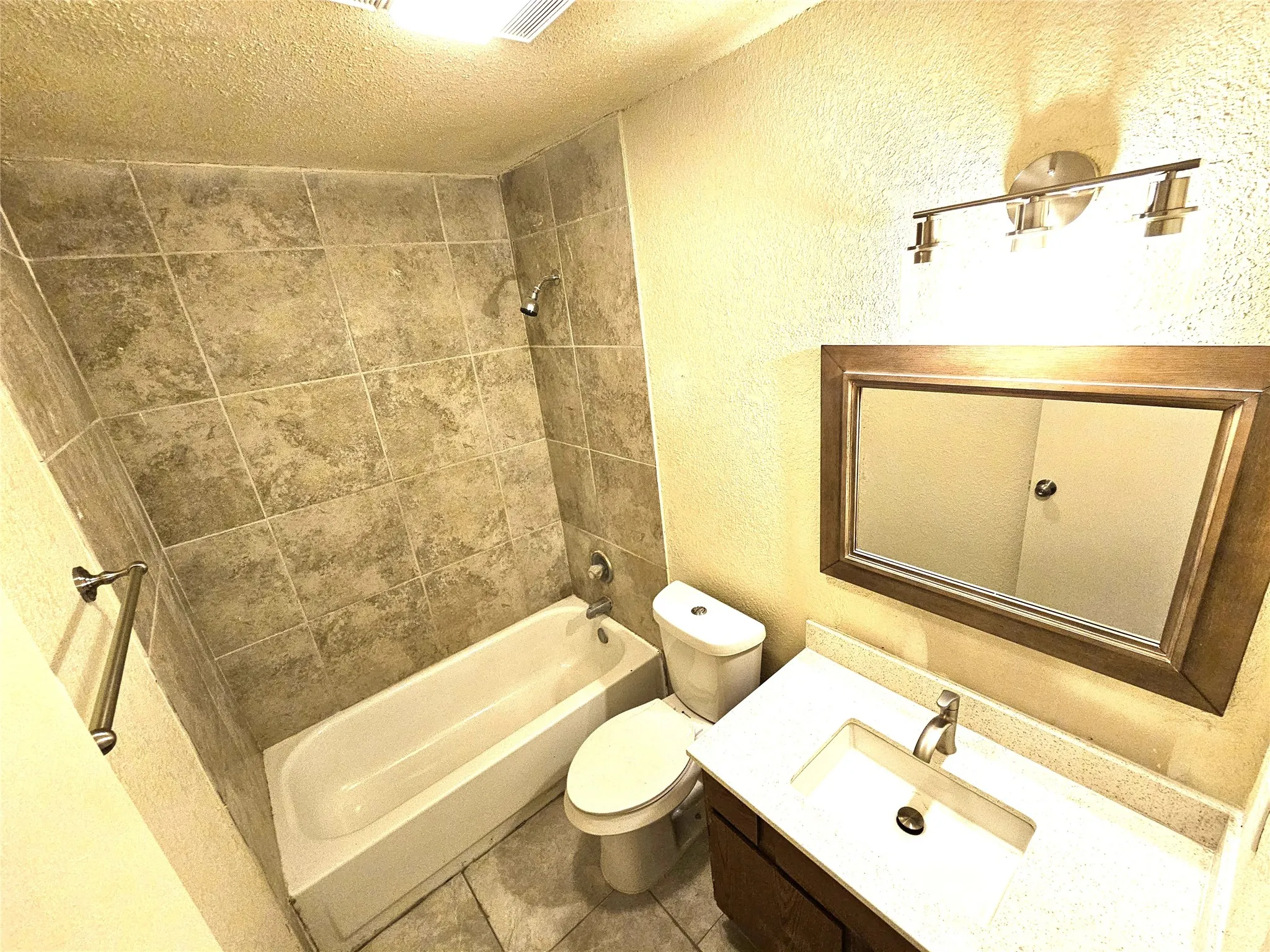 Full bathroom featuring vanity, tiled shower / bath combo, and toilet. It's upstairs in between 2 good size bedrooms. (unit B)