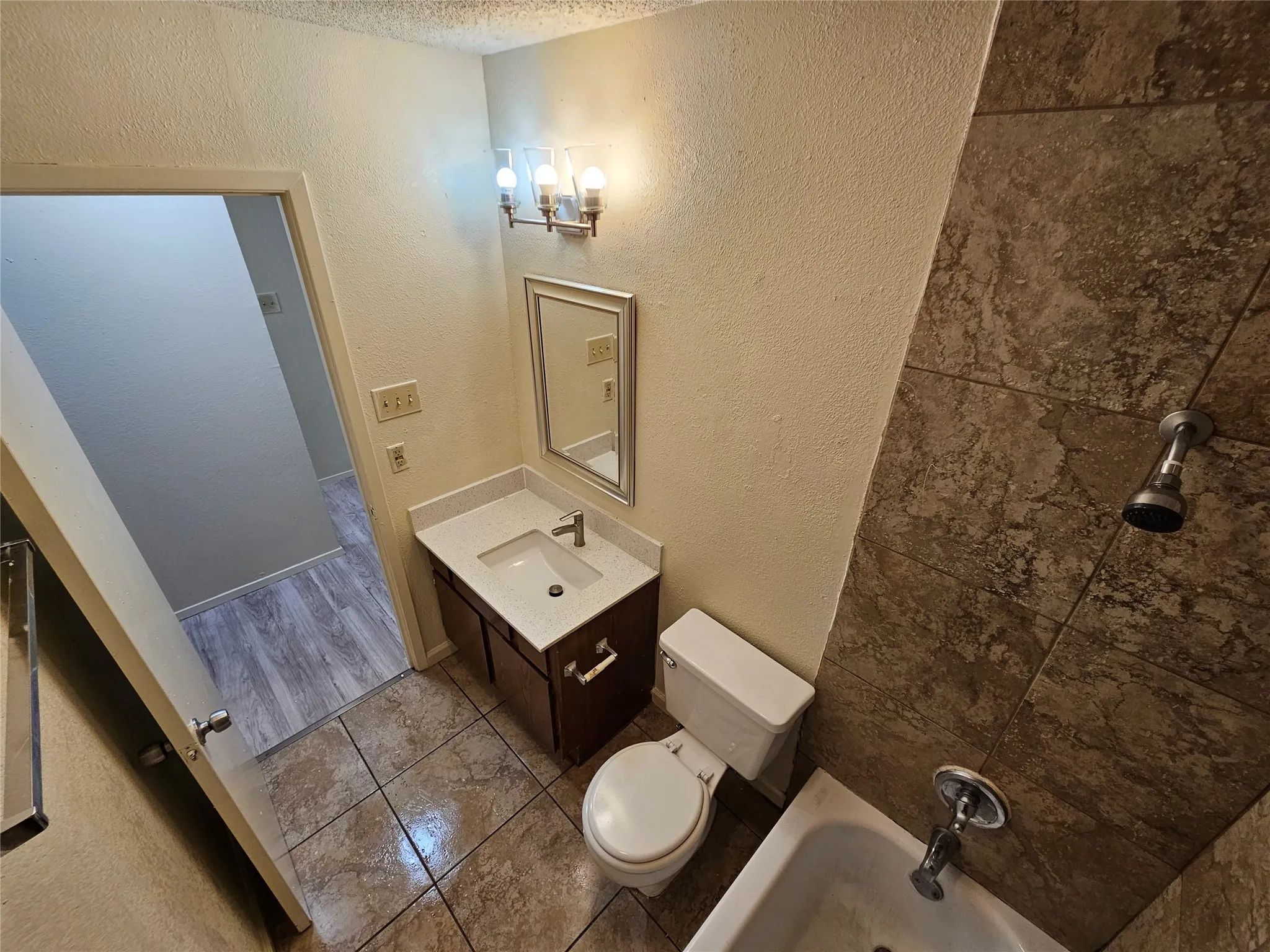 Full bathroom featuring vanity, tiled shower / bath combo, and toilet. It's upstairs in between 2 good size bedrooms. (unit C)