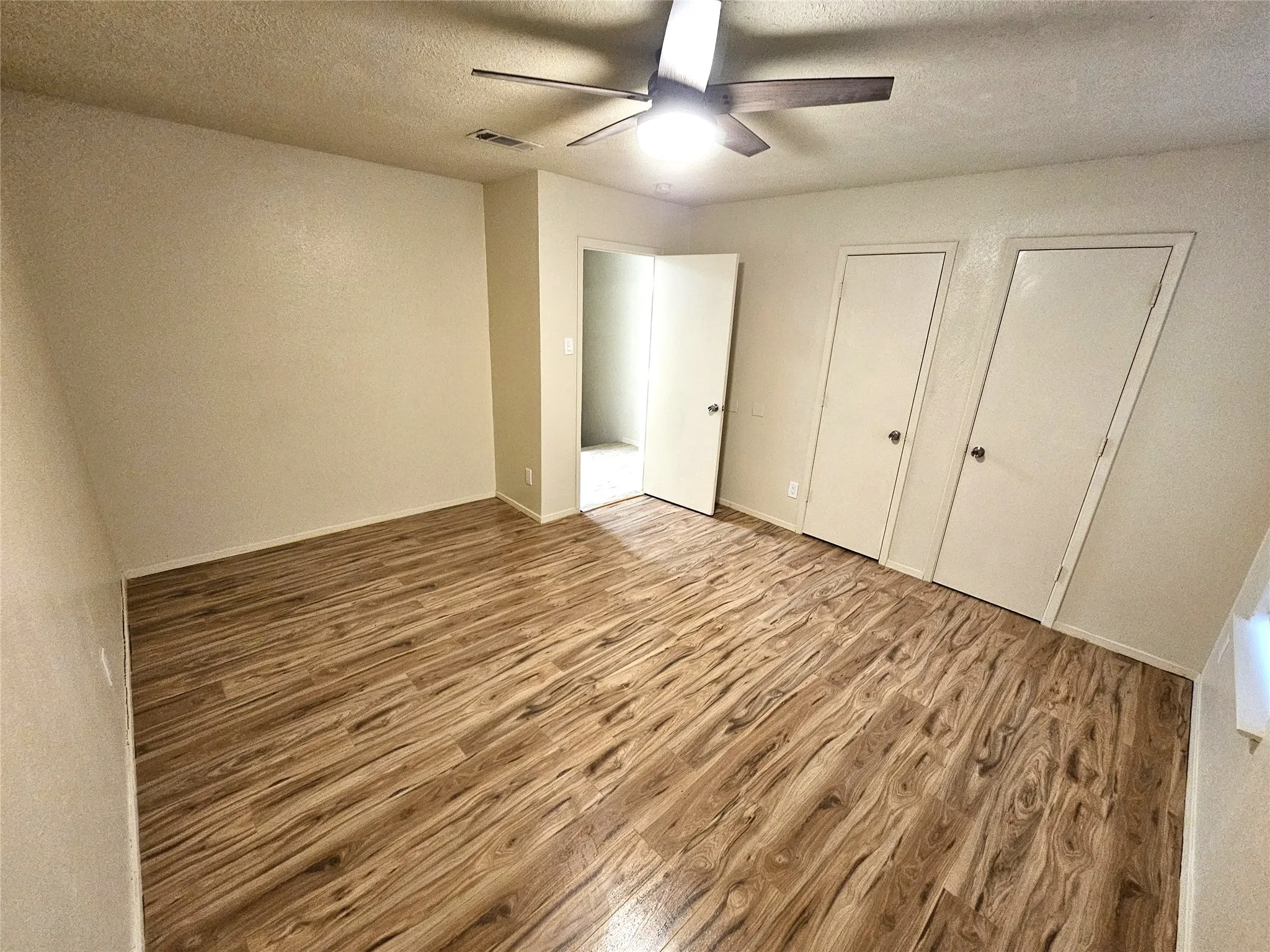 Bedroom #1-spacious bedroom (13x13) with new modern ceiling fan & wood laminate flooring - no carpet in this townhome. Stairs is wood laminate as well. (unit C)
