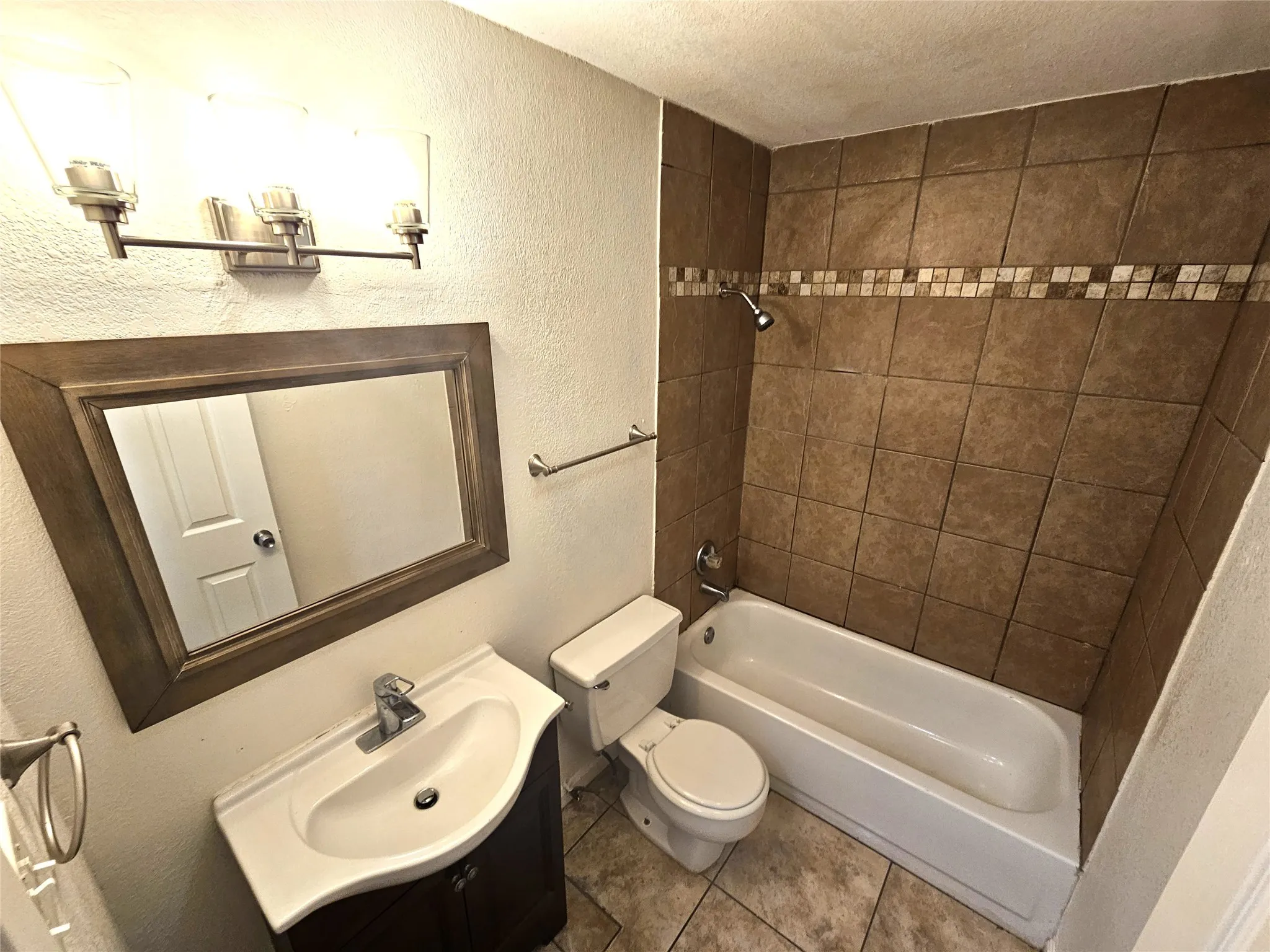 Full bathroom featuring vanity, tiled shower / bath combo, and toilet. It's upstairs in between 2 good size bedrooms. (unit D)