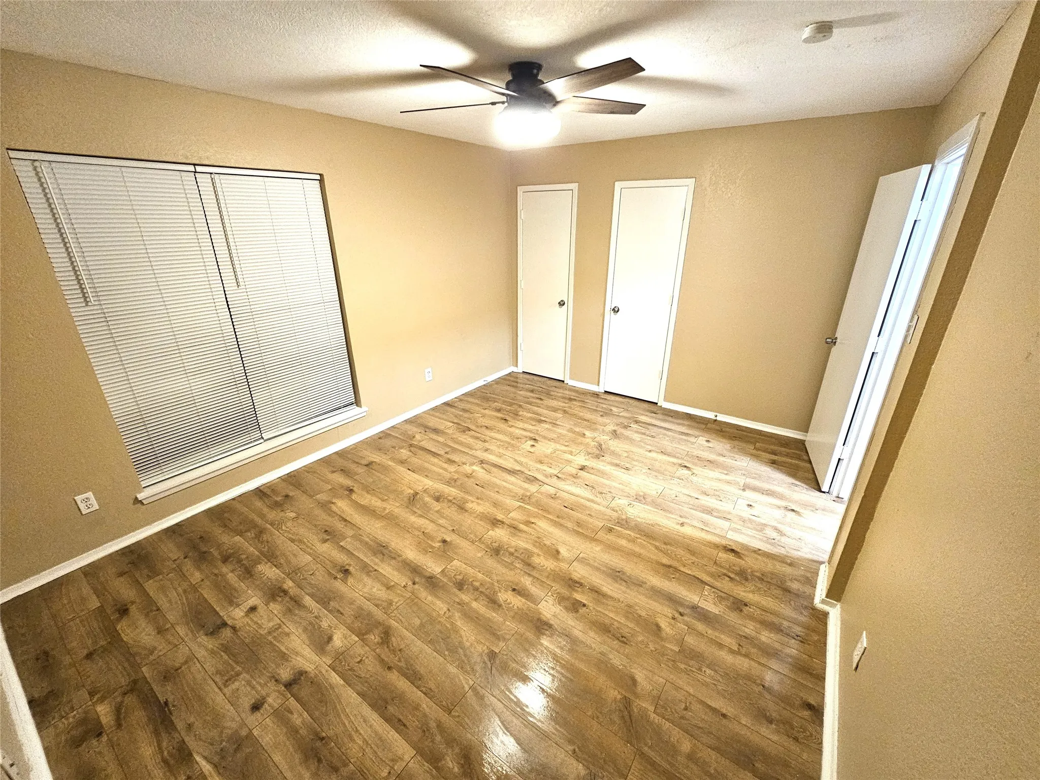 Bedroom #1-spacious bedroom (13x13) with new modern ceiling fan & wood laminate flooring - no carpet in this townhome. Stairs is wood laminate as well. (unit D)