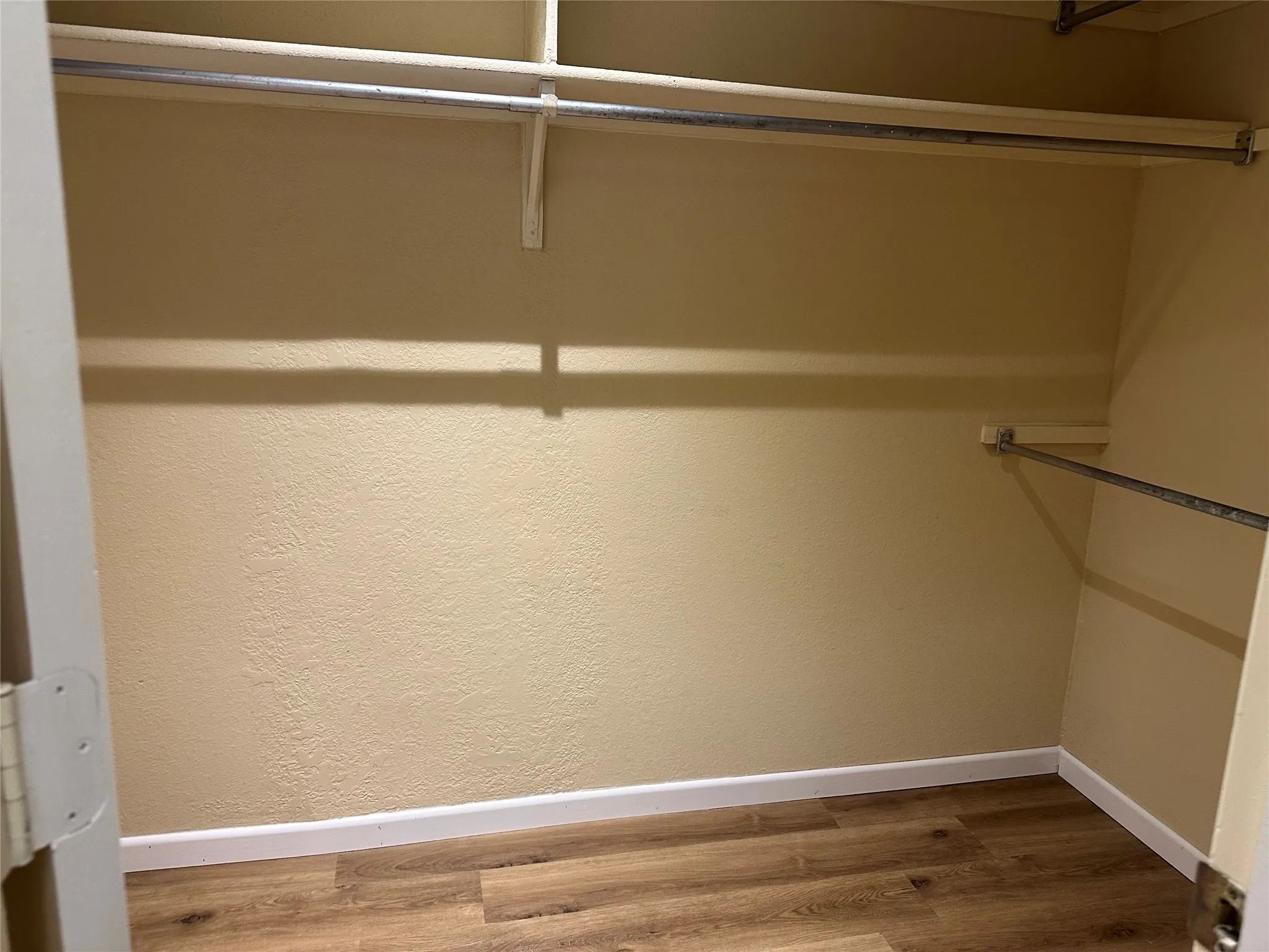 Wood-finish flooring, multiple hanging rods, and integrated shelving