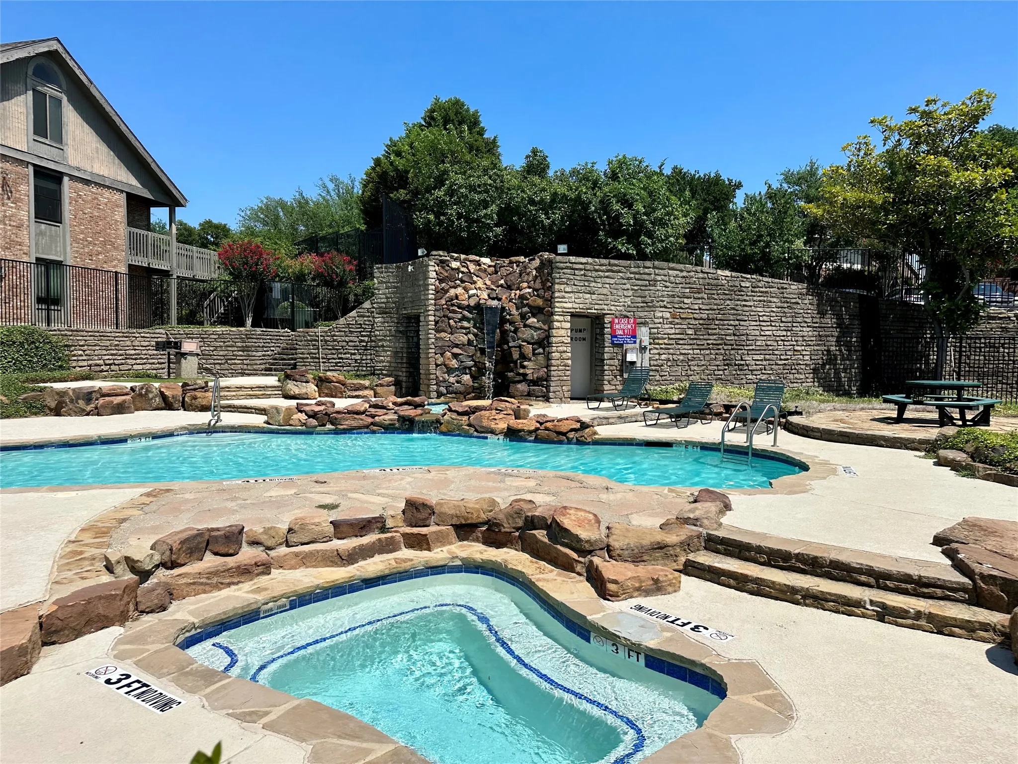 Resort-style pool with integrated spa and rock-faced waterfall feature