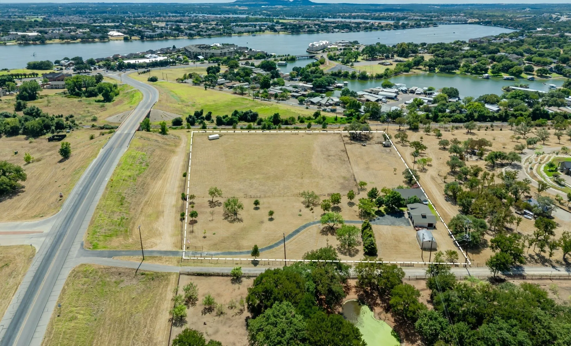 Expansive parcel with clear boundary delineation, featuring a primary residence, detached outbuilding, and mature trees throughout