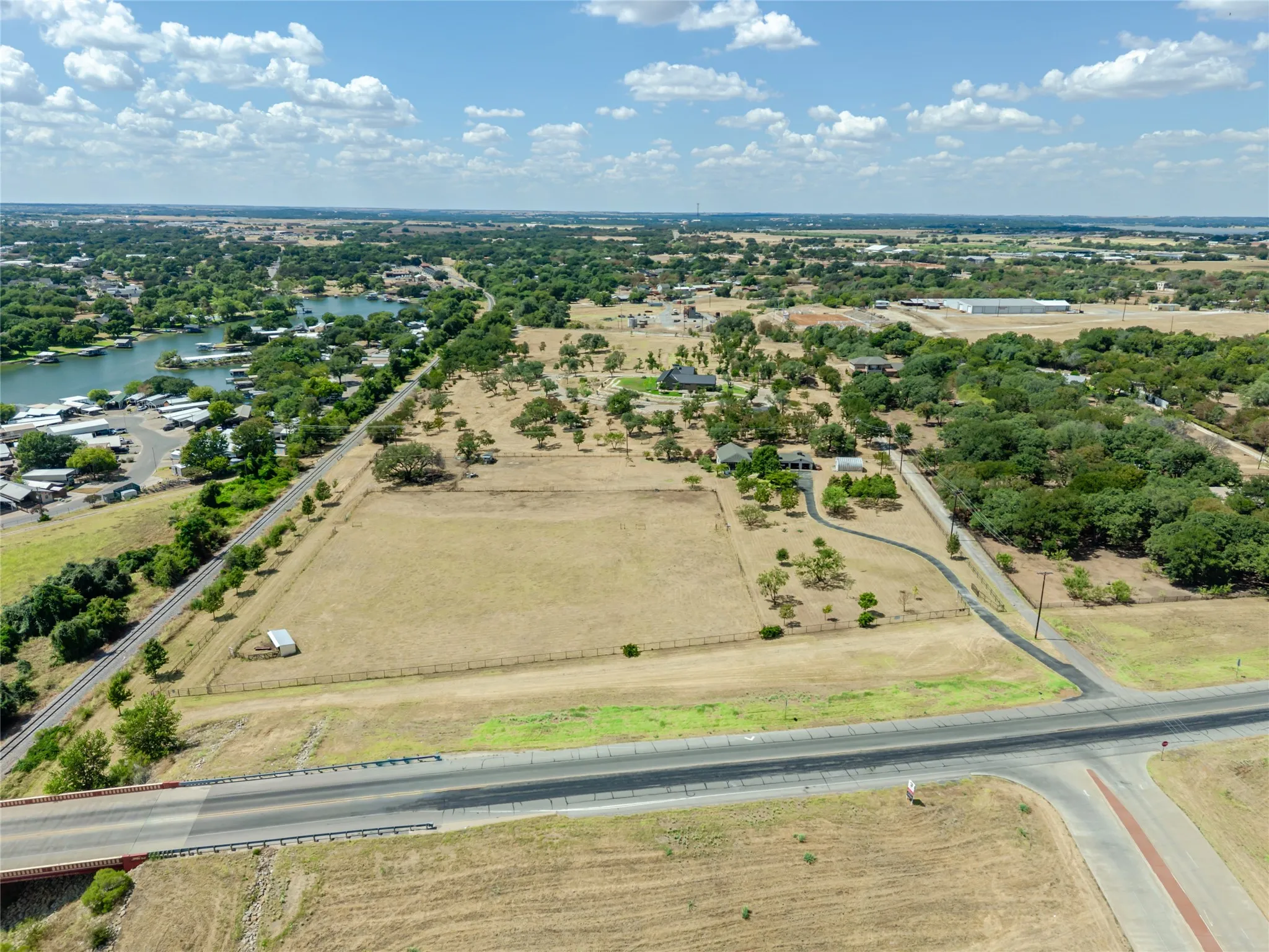 Expansive lot with visible road frontage, a paved driveway, and mature trees