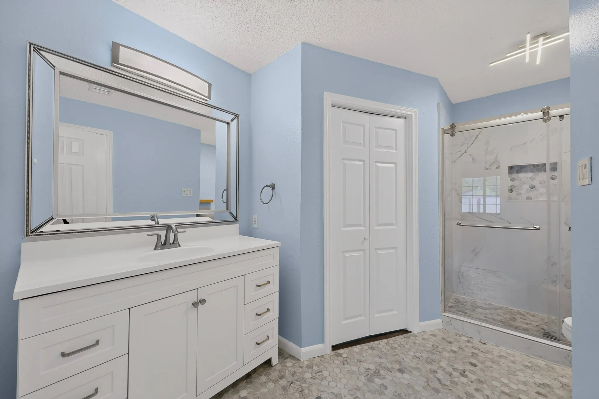 White vanity with a solid surface countertop and undermount sink