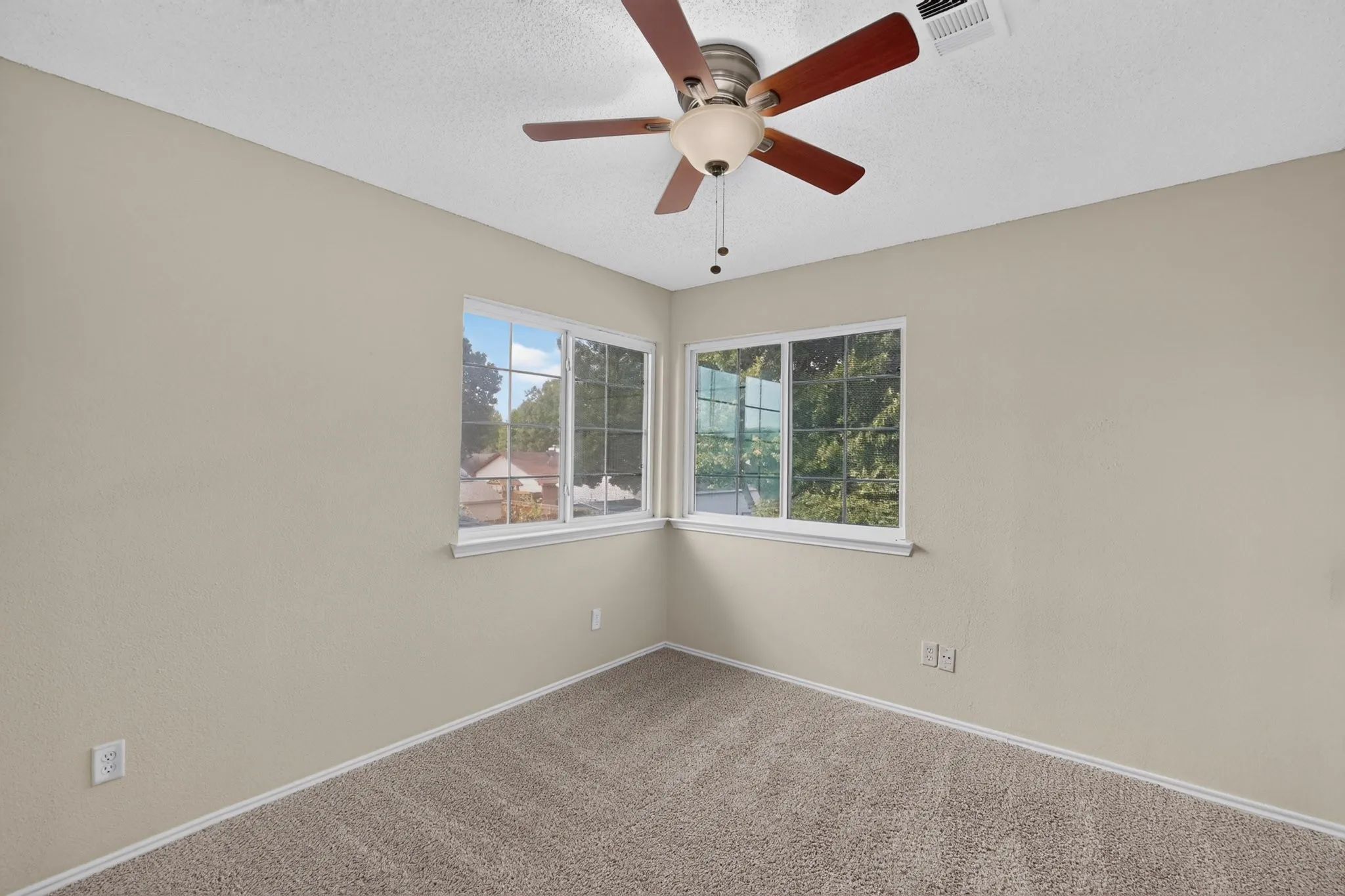 Recessed lighting with a ceiling fan, dual pane windows, and neutral carpeting