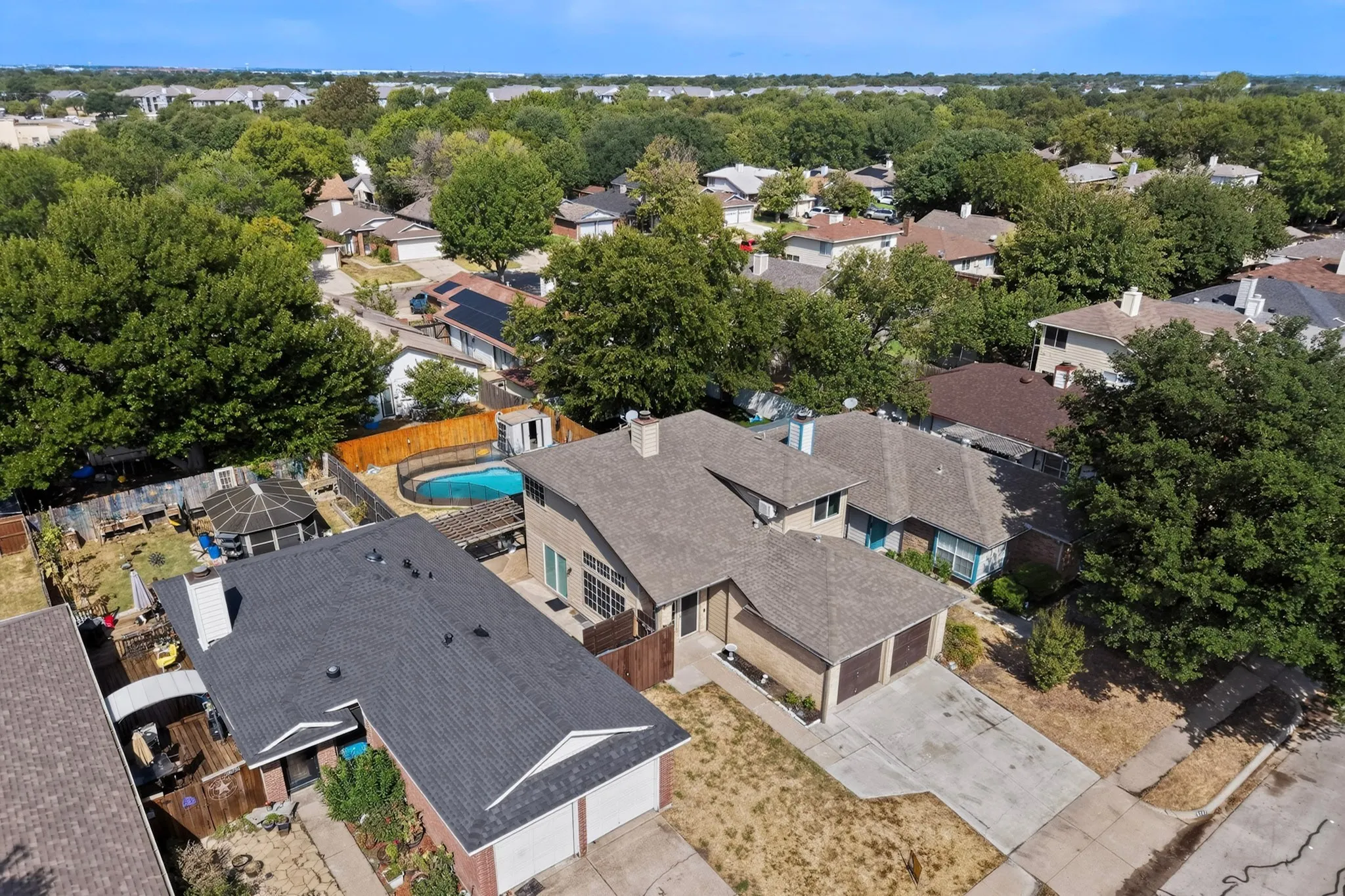 Single-family residence featuring an attached two-car garage, pitched roof, and a fenced backyard with an in-ground swimming pool