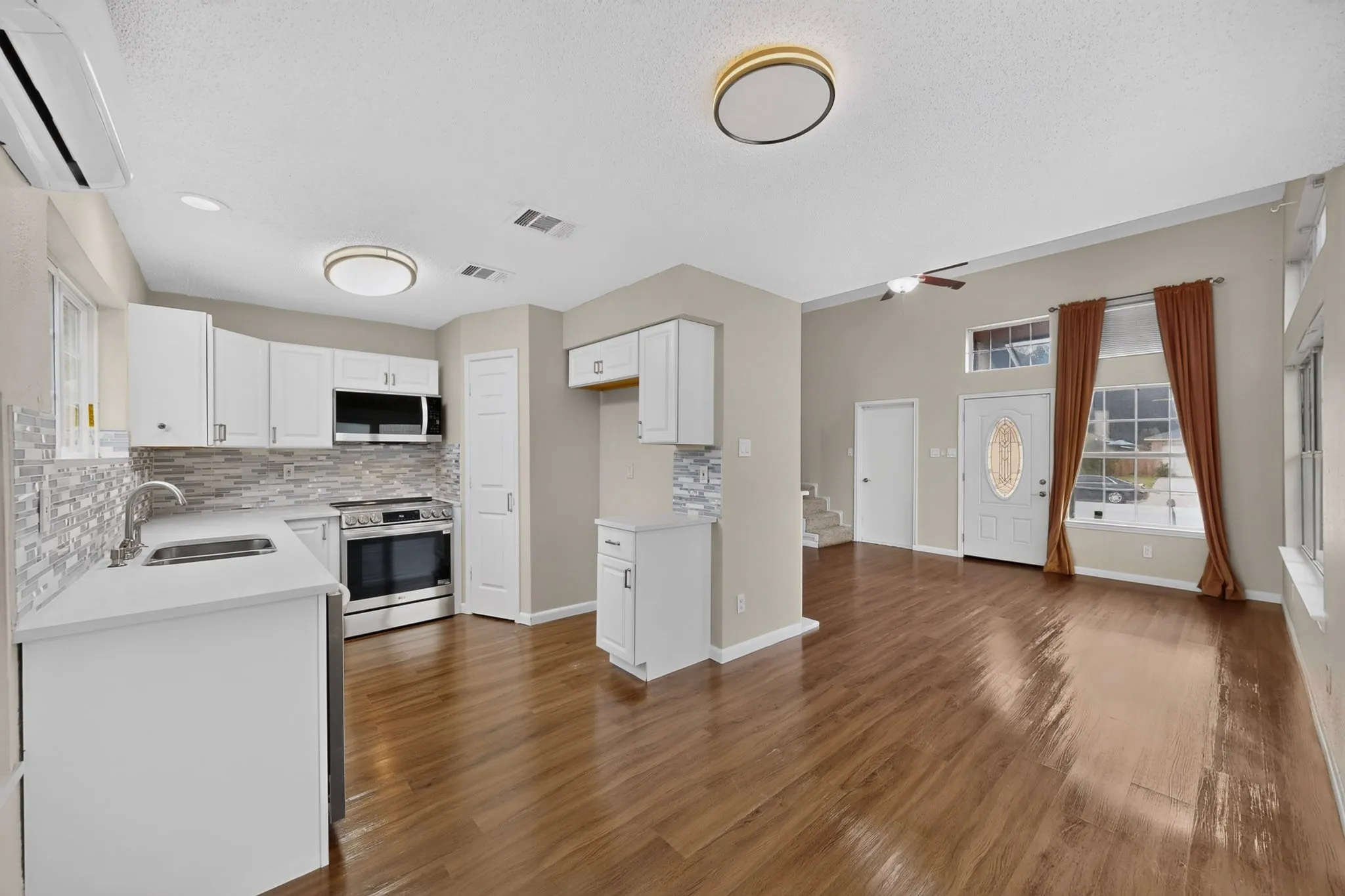 Kitchen featuring white cabinetry, stainless steel appliances, and a mosaic tile backsplash